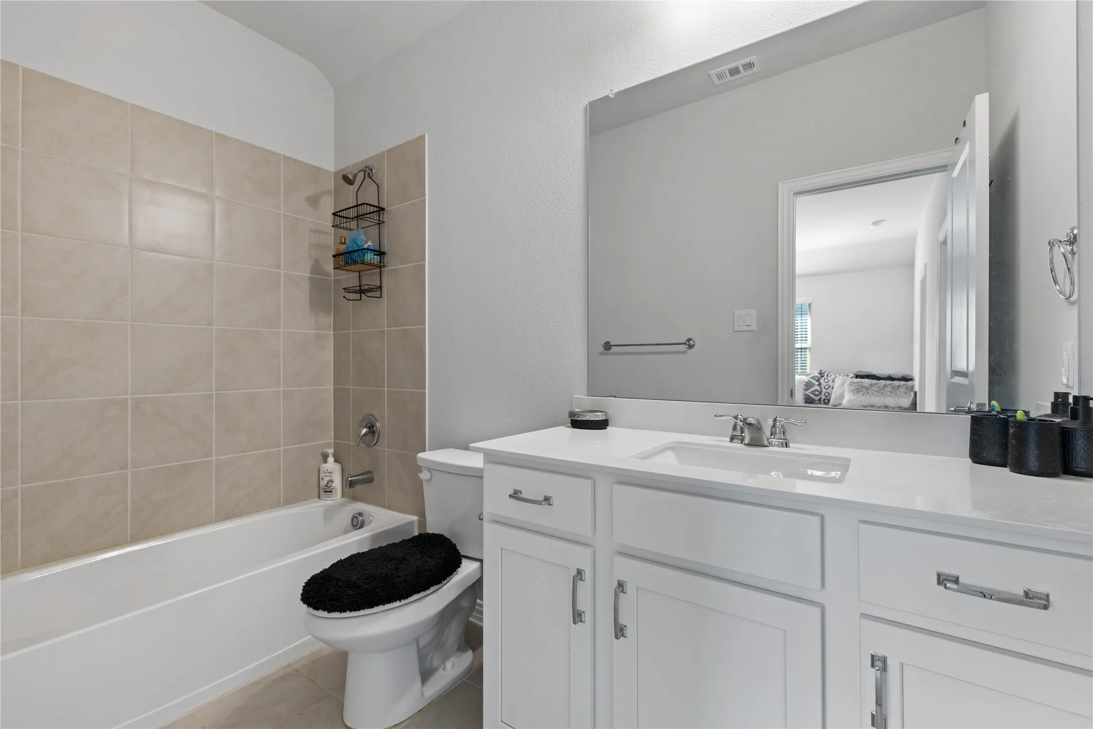 Beautiful upstairs full bathroom featuring quartz vanity, modern cabinetry, tiled tub and shower combination, designer fixtures, and convenient access to the secondary bedrooms and game room.