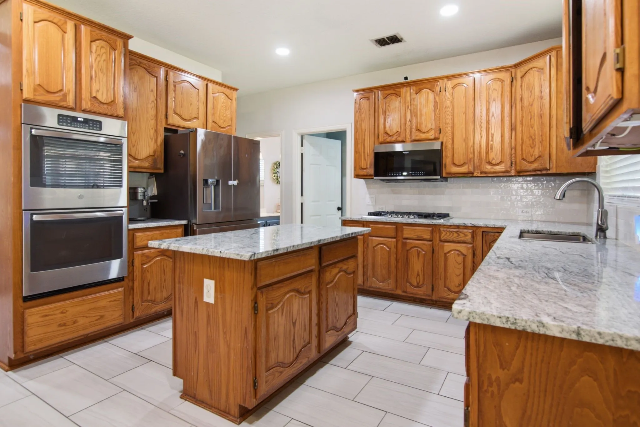 Kitchen featuring double oven, gas cook-top, SS appliances, built-in microwave.