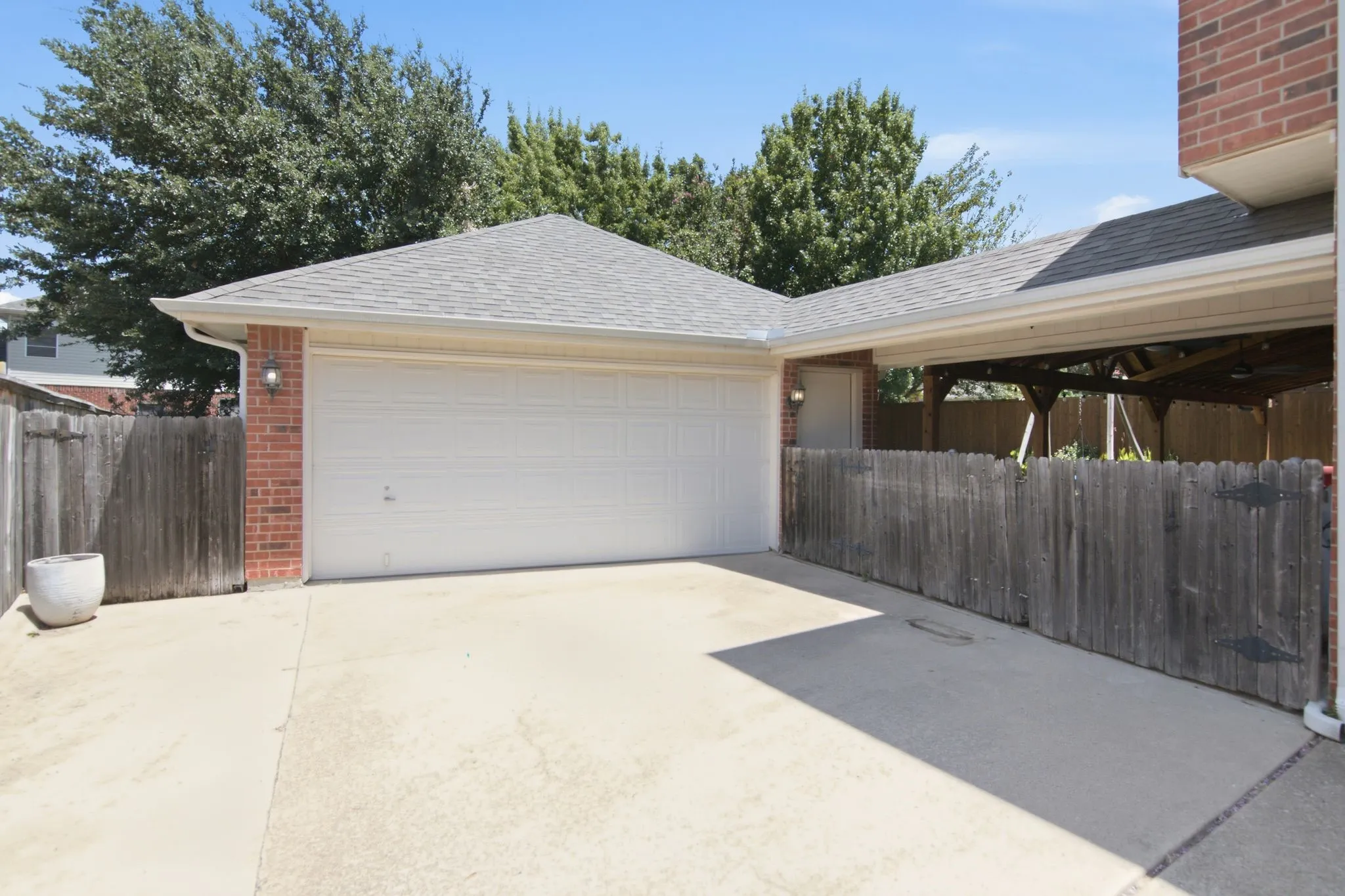 Spacious two-car garage featuring a concrete driveway and a classic brick exterior.