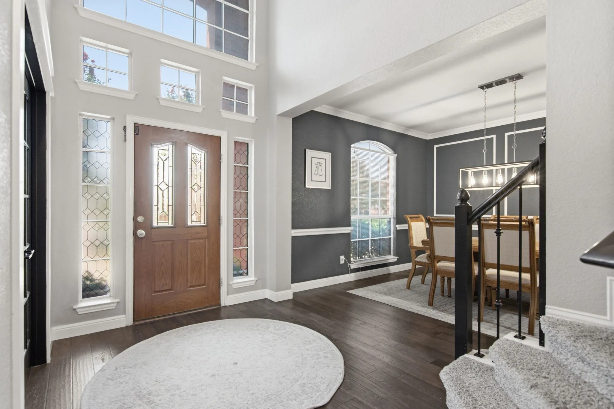 An entryway with a wood-paneled door accented by decorative glass inserts, framed by multiple transom windows.