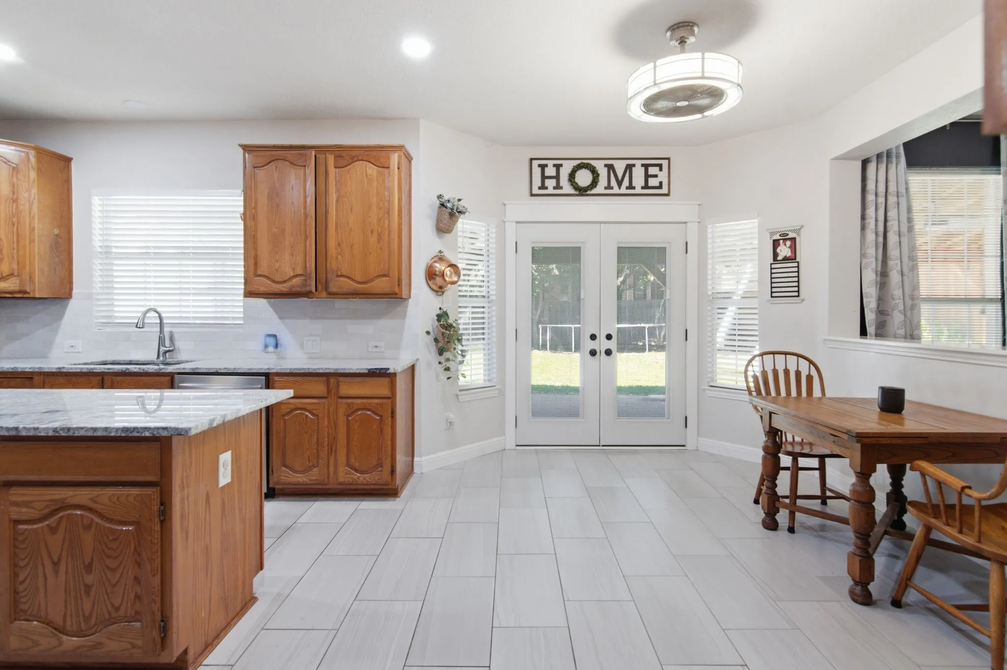 Kitchen area featuring wood-finish cabinetry, granite countertops, and a central island