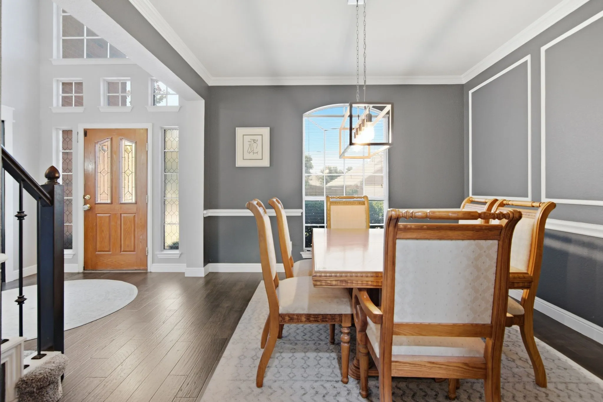 Elegant dining area featuring wainscoting and a contemporary linear chandelier