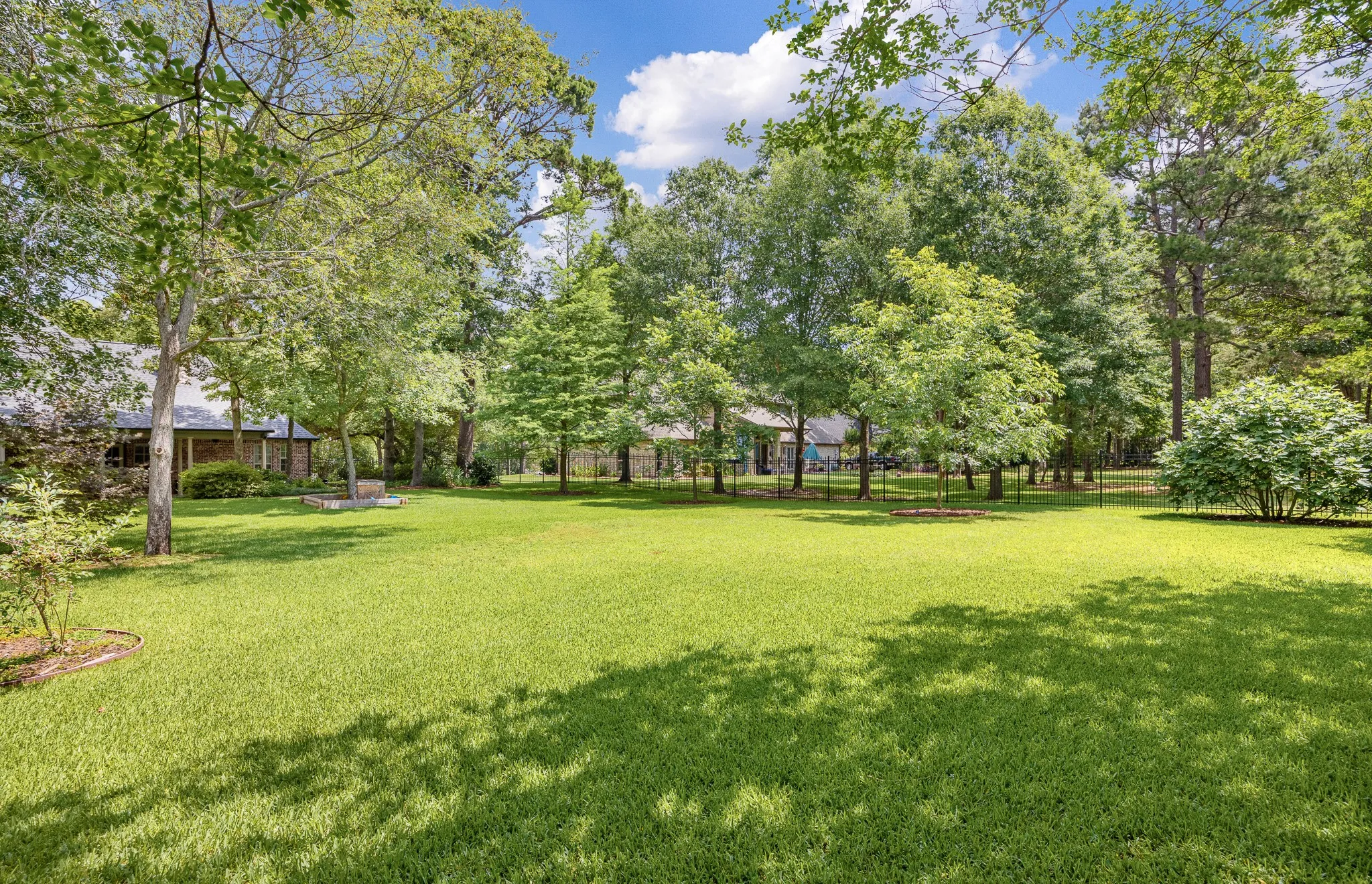 Expansive lawn area featuring mature trees and established landscaping