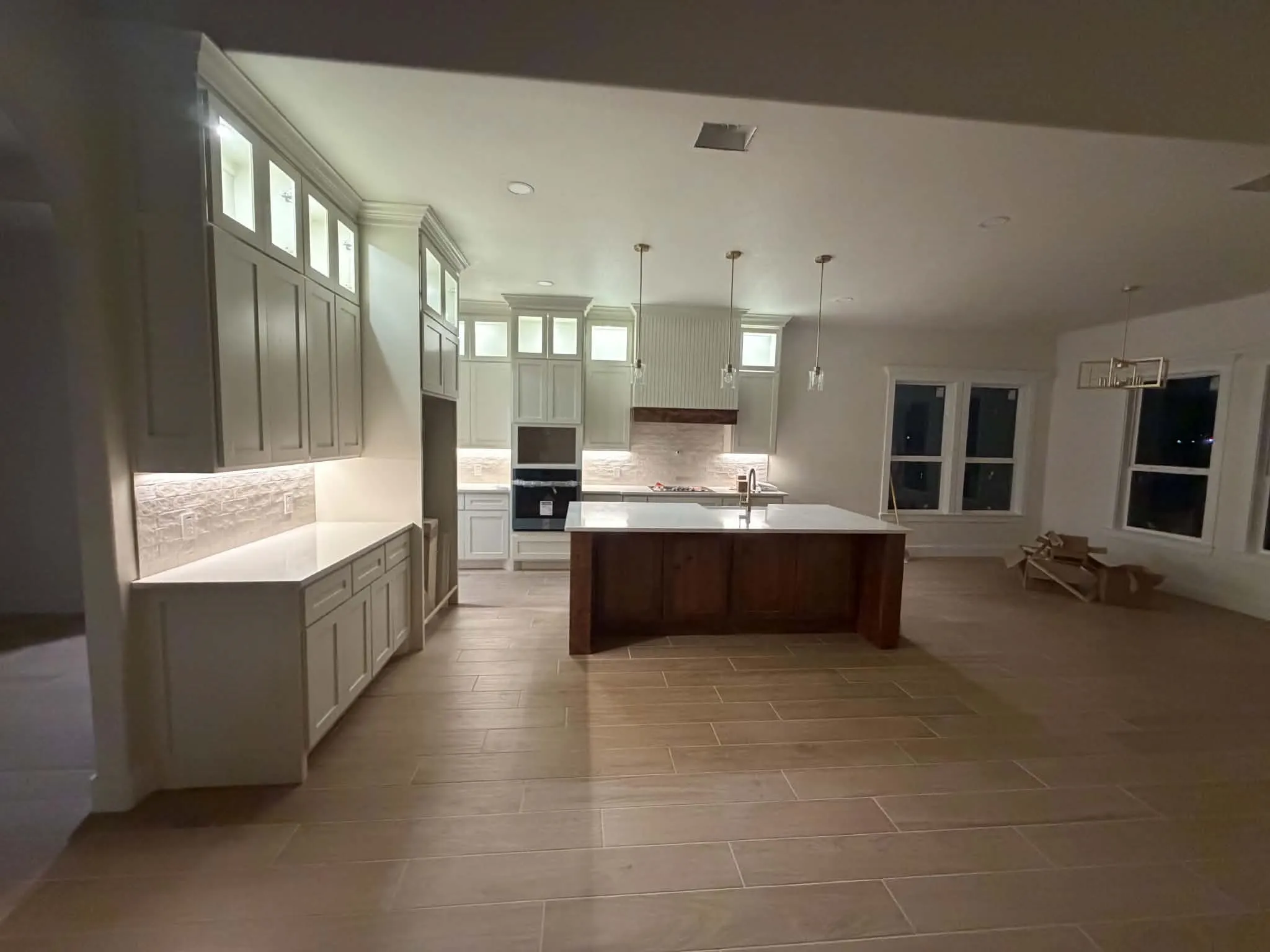 Spacious kitchen featuring an expansive island, integrated appliances, and extensive cabinetry with under-cabinet lighting