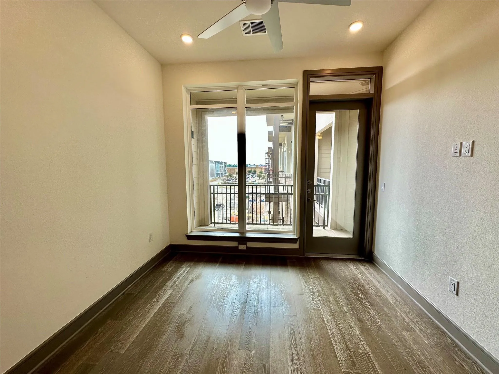 Room featuring wood-finish flooring, a ceiling fan with integrated lighting, and recessed ceiling lights