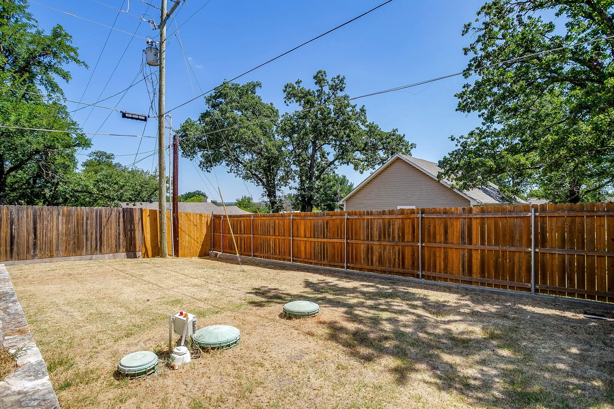 Fenced backyard featuring wood privacy fencing
