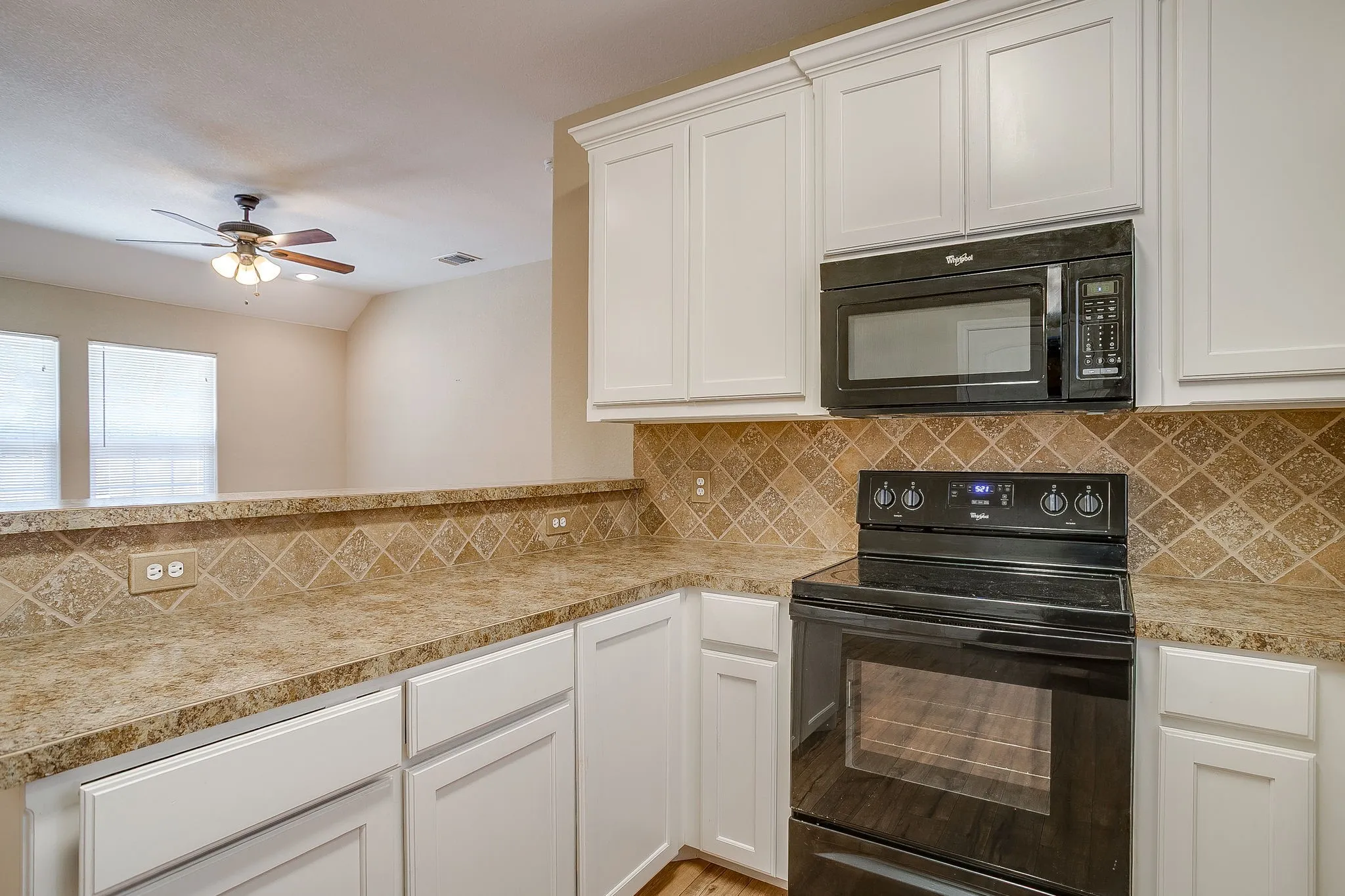 Kitchen featuring white cabinetry, a black oven range, and a black over-the-range microwave