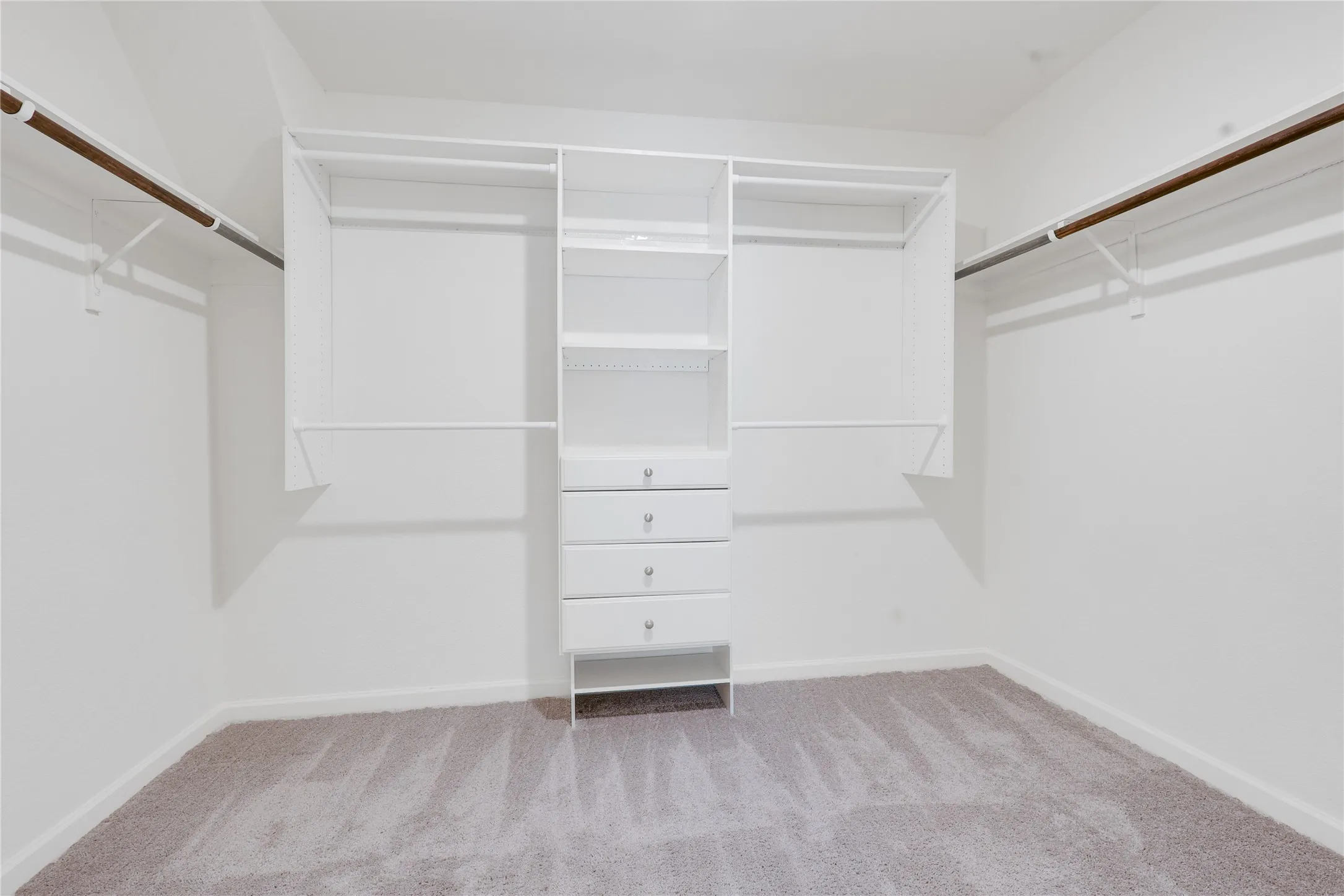 Walk-in closet featuring built-in custom shelving, integrated drawers