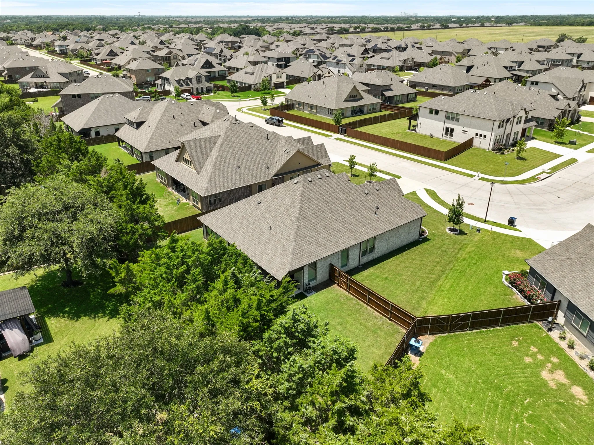 Expansive residential community featuring a variety of single-family homes with pitched roofs, individual fenced yards, and mature landscaping