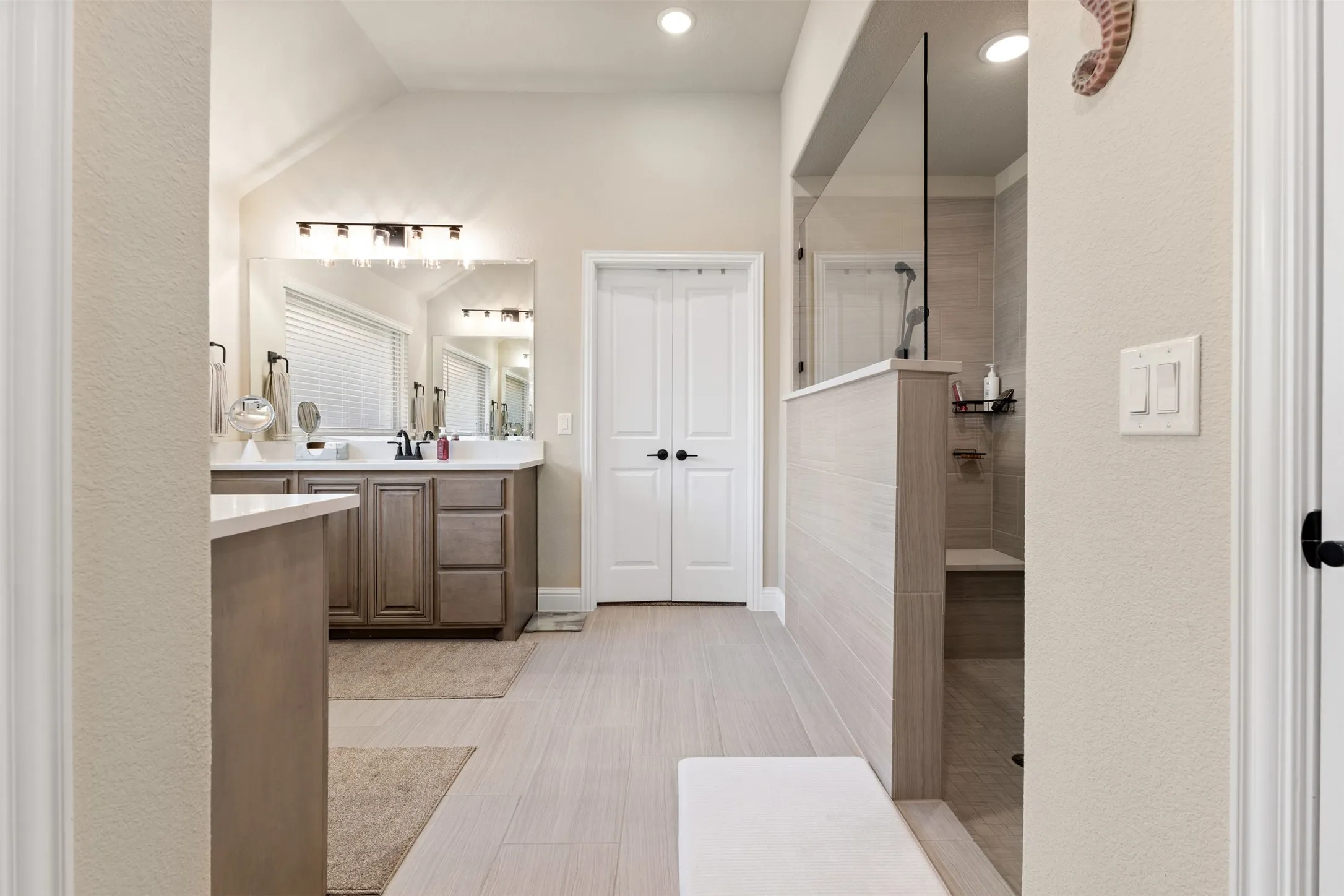 Contemporary bathroom featuring a large walk-in shower with a built-in bench, glass enclosure, and tiled walls