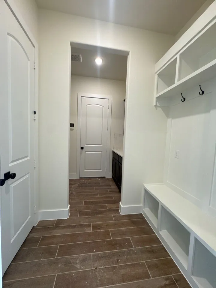 Built-in storage bench with cubbies, upper shelving, and coat hooks