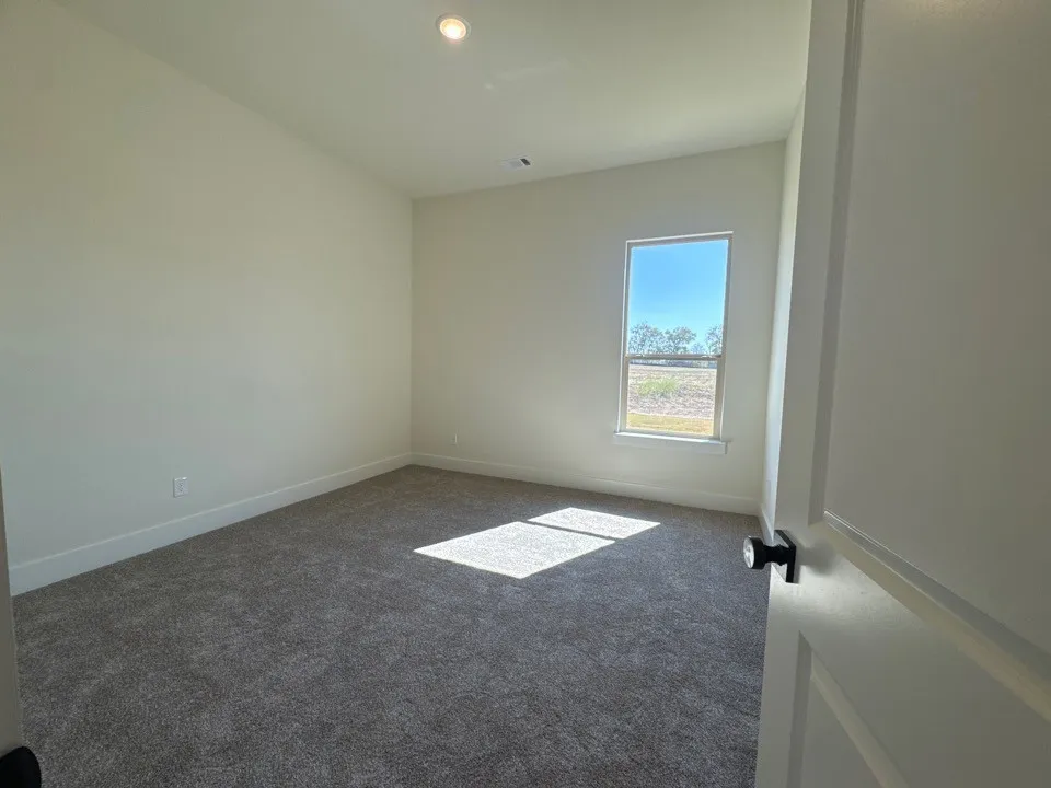 Recessed ceiling lighting, a single window, neutral wall tones, and gray carpeting