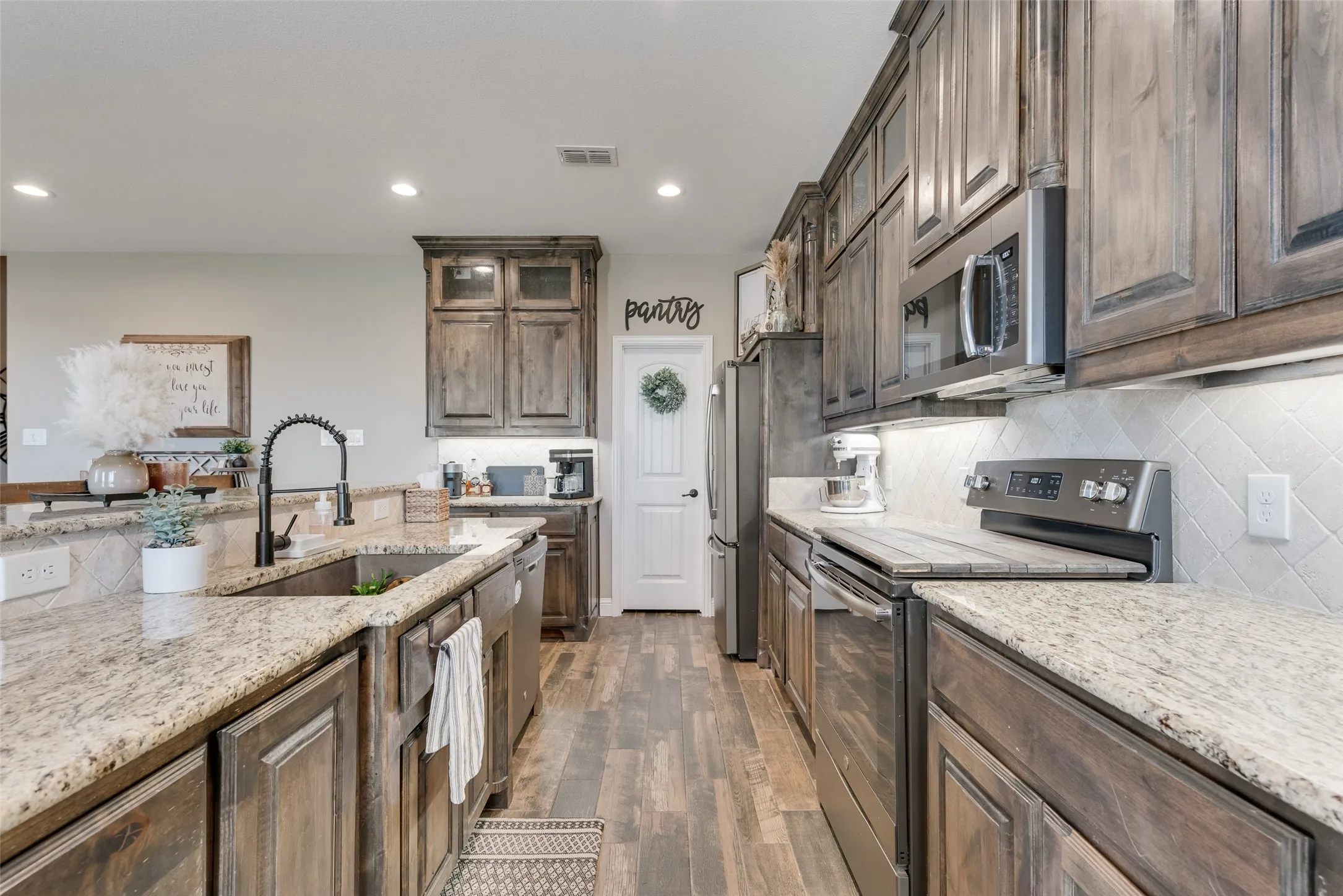 Gourmet kitchen featuring wood-finish flooring, granite countertops, and full-height subway tile backsplash