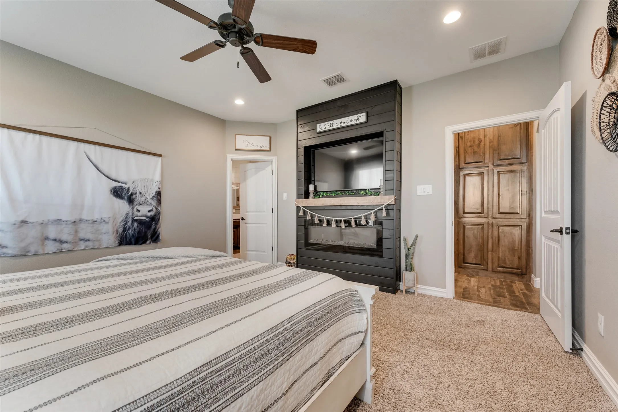 Carpeted room featuring a ceiling fan, recessed lighting, and a dark shiplap accent wall with an integrated electric fireplace