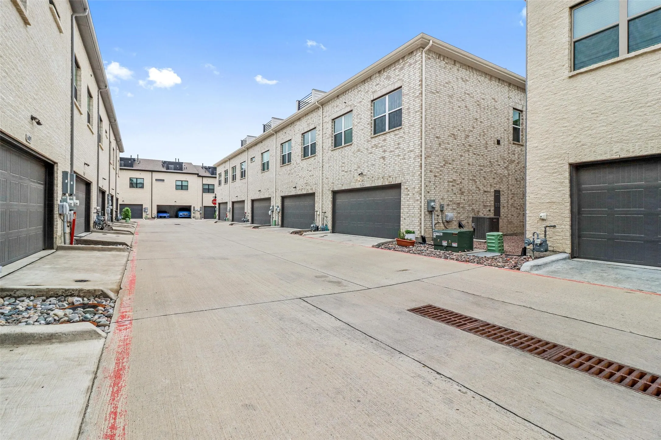 Concrete driveway providing access to multiple brick-clad townhome units