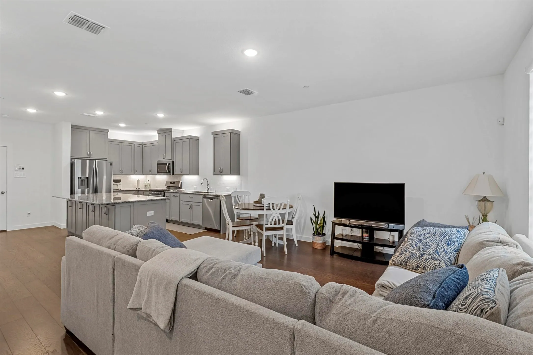 Open-concept living space featuring wood flooring and recessed lighting