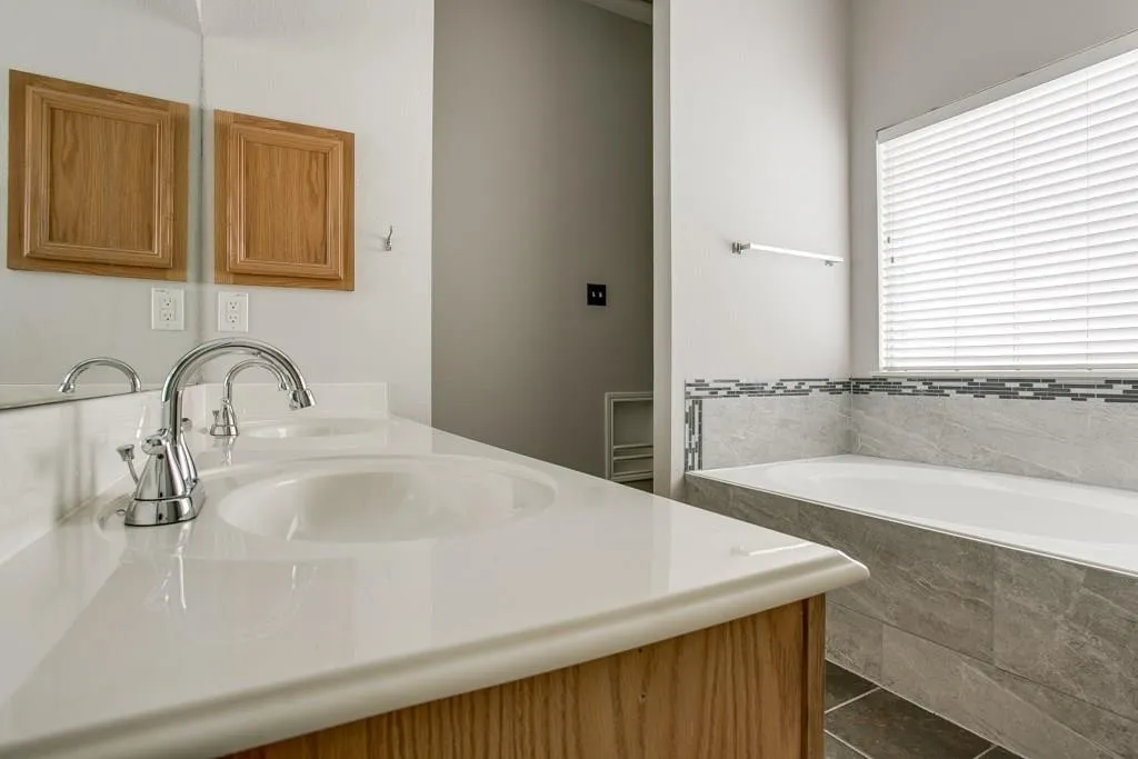 Bathroom featuring a white countertop with an undermount sink, chrome faucet, and a large mirror