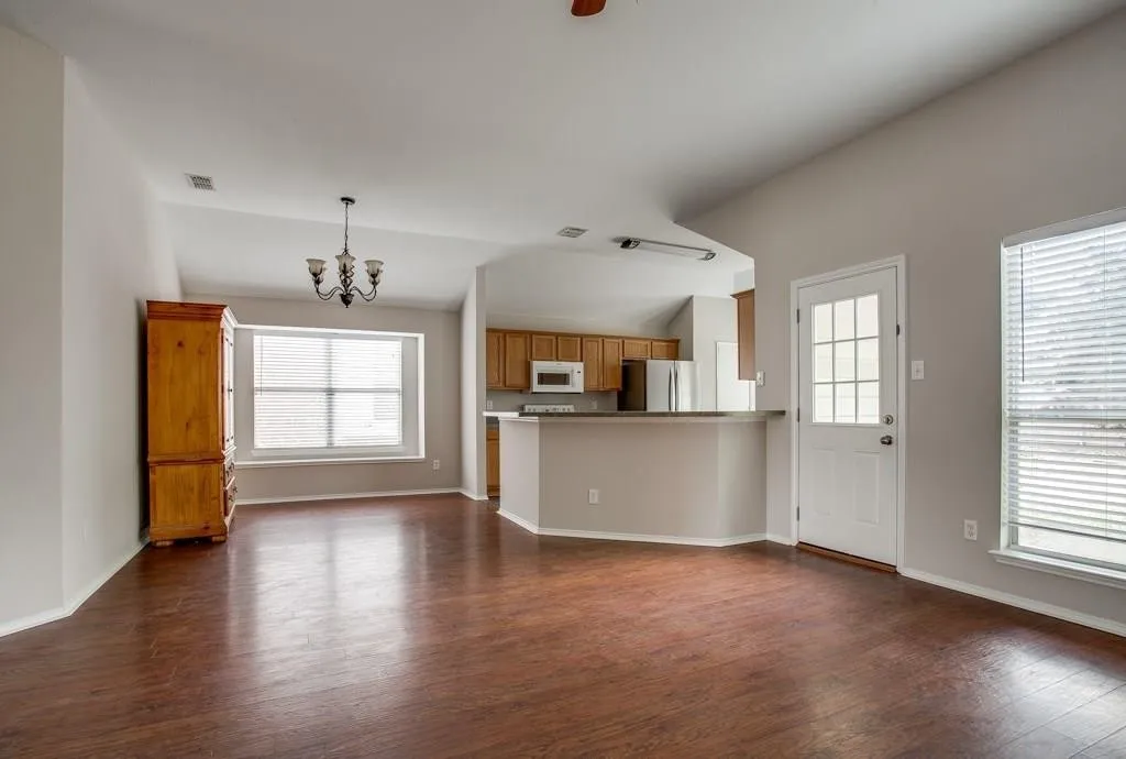 Spacious living area featuring rich wood-finish flooring and vaulted ceilings