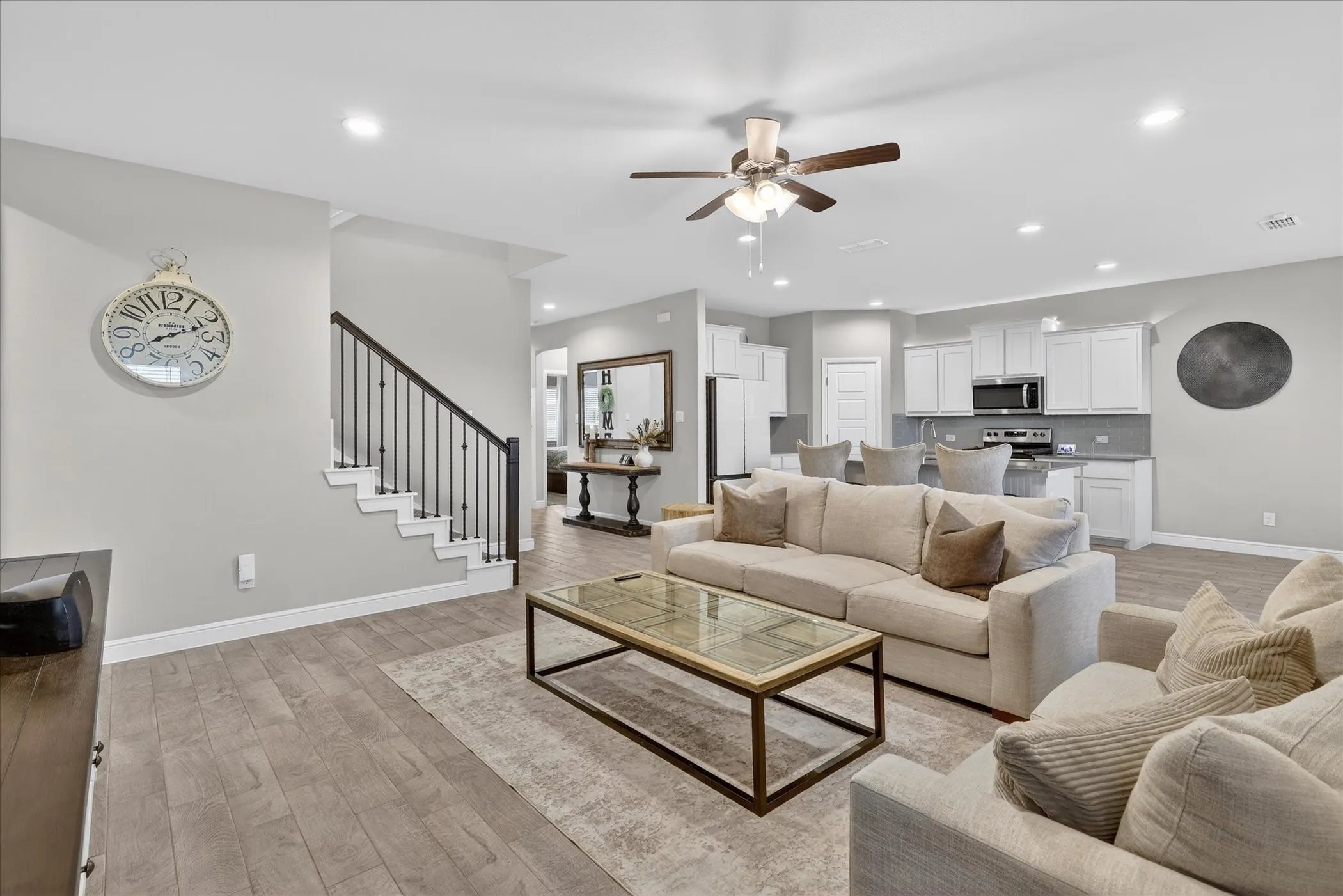 Open-concept living area with wood-finish flooring, recessed lighting, and a ceiling fan