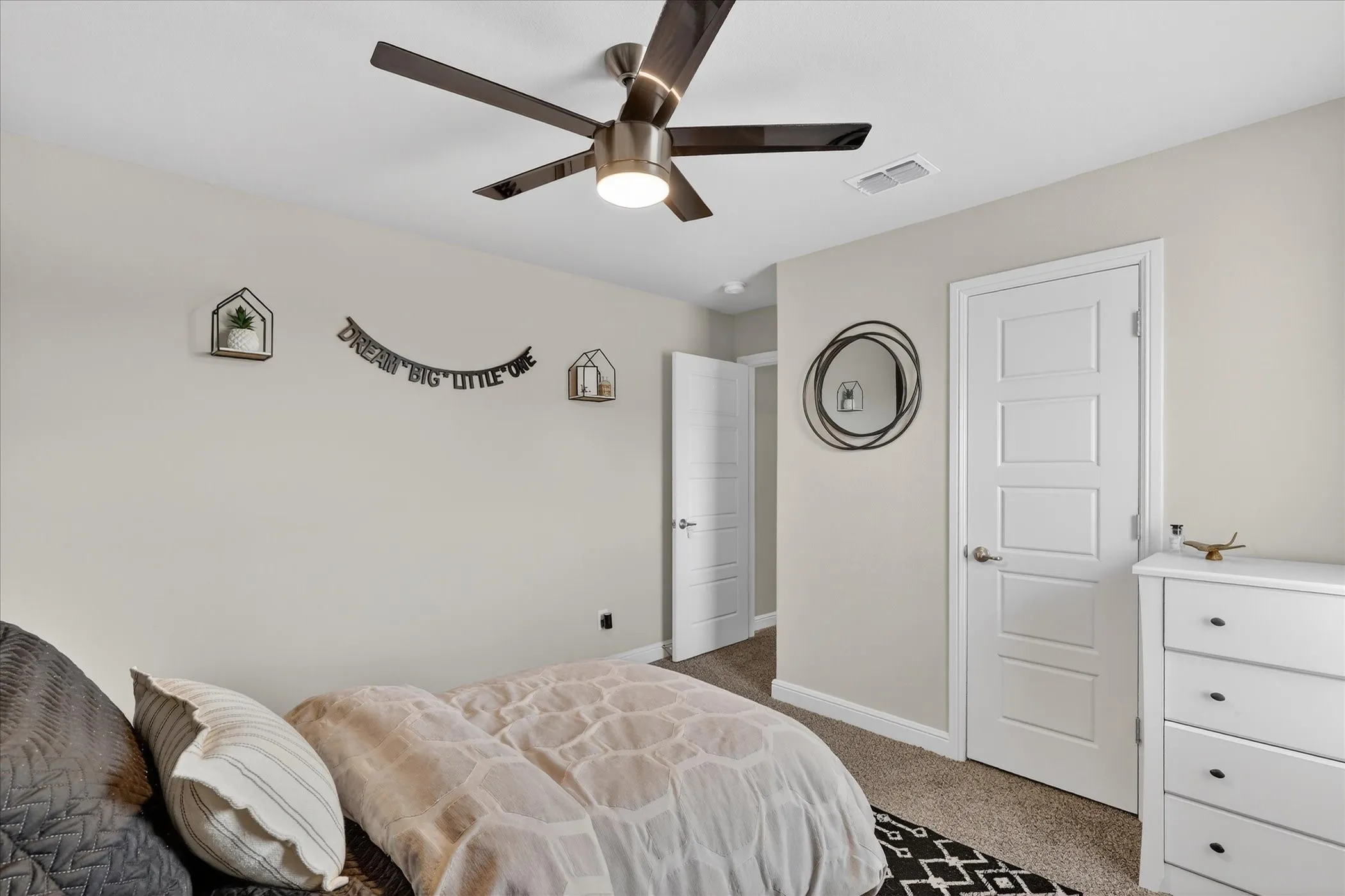 Bedroom featuring a contemporary ceiling fan with integrated lighting, neutral wall tones, and carpet flooring