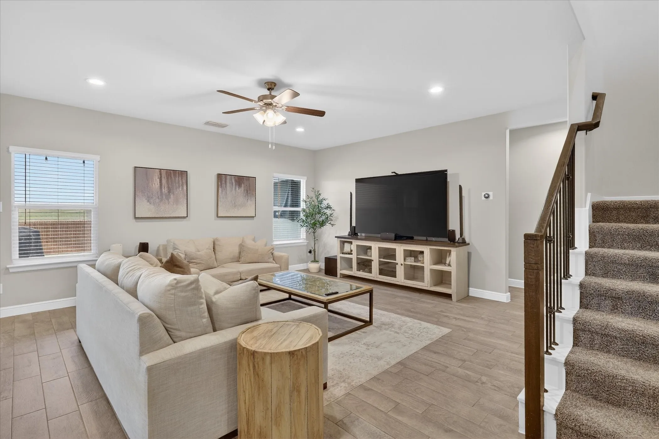 Open-concept living area featuring wood-finish flooring, recessed lighting, and a ceiling fan