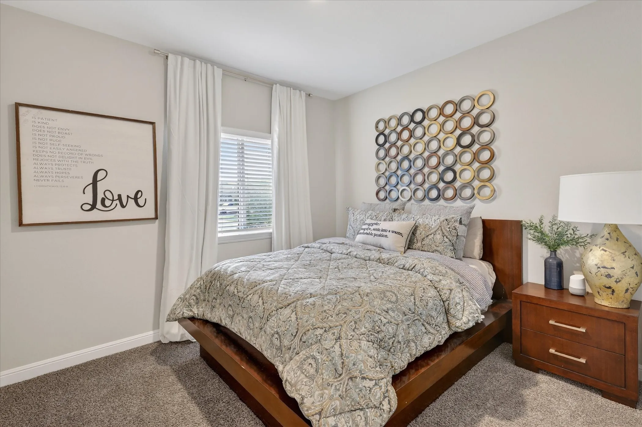 Carpeted room with a window featuring horizontal blinds and white curtains