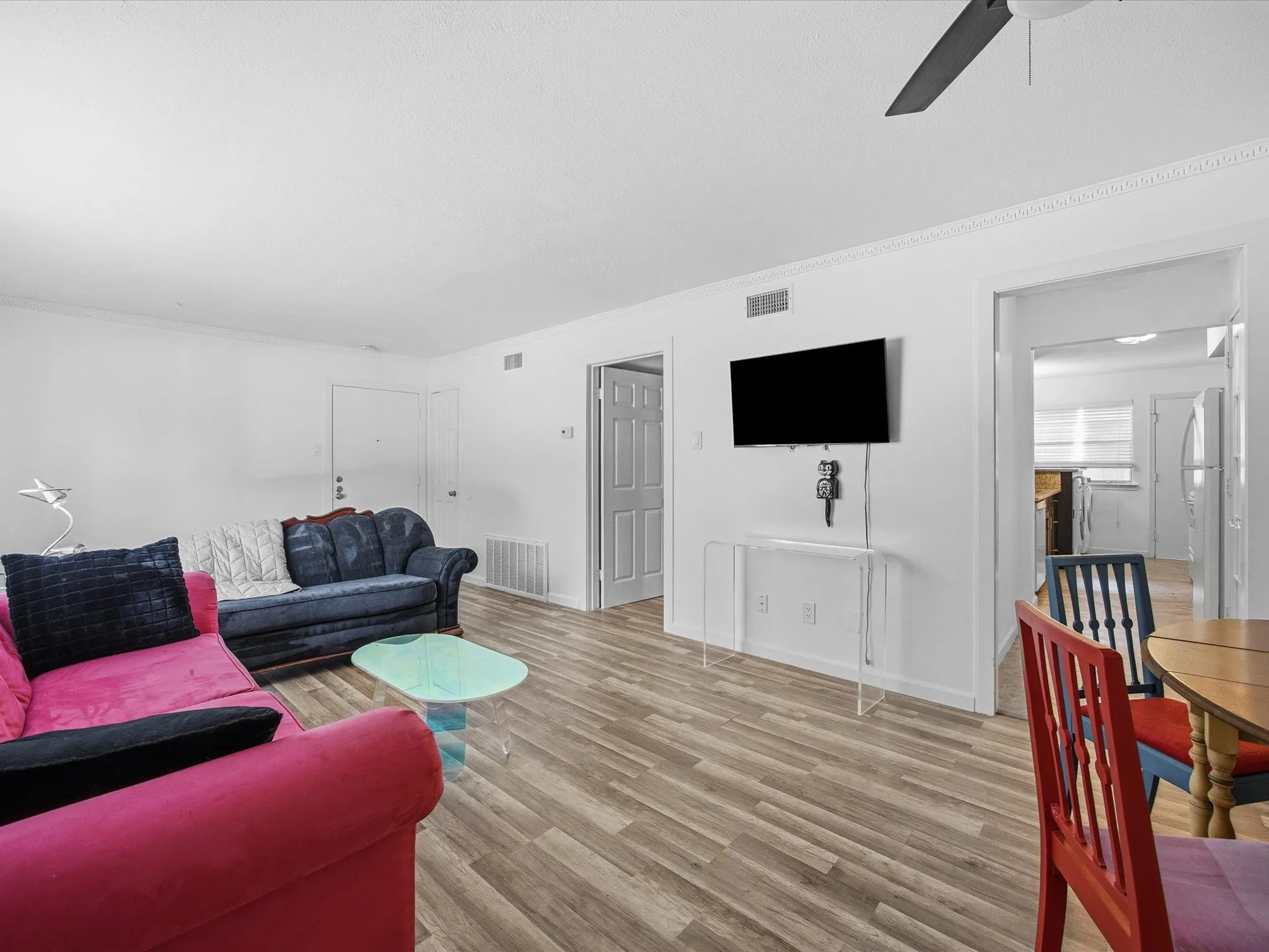 Living room featuring wood finished floors, ornamental molding, and ceiling fan