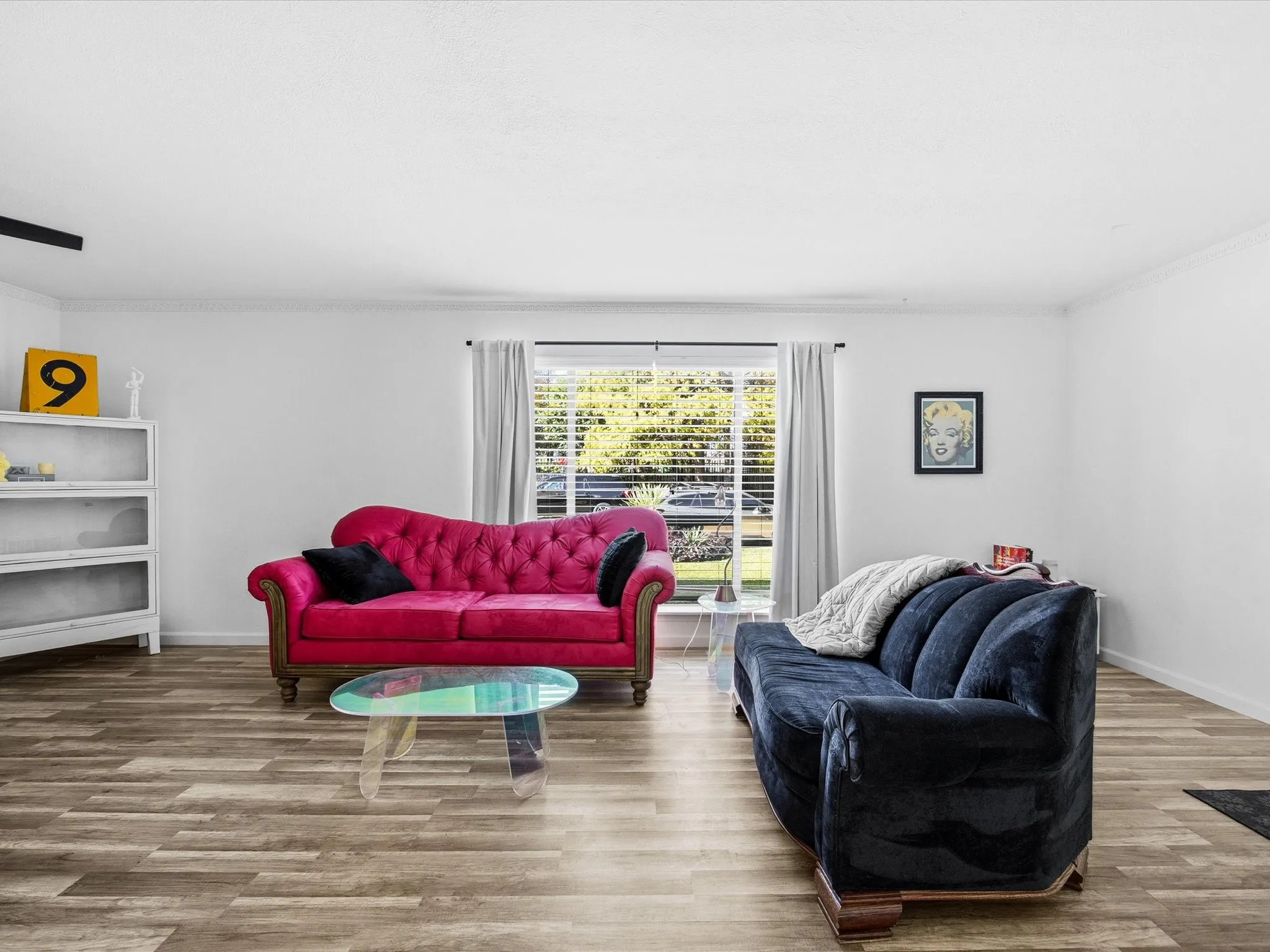 Living area with crown molding and wood finished floors