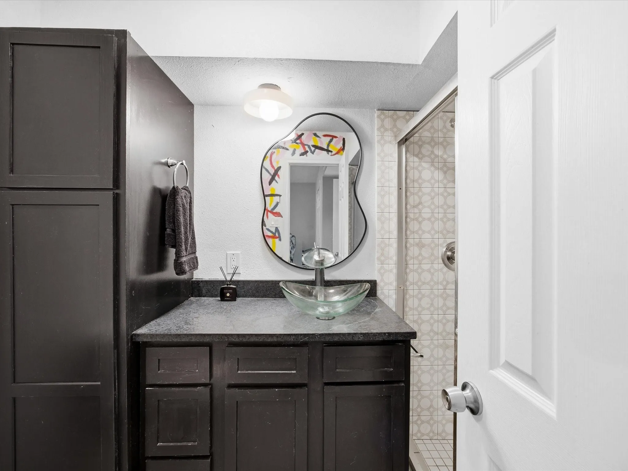 Primary Bathroom featuring a shower stall, vanity, and a textured ceiling