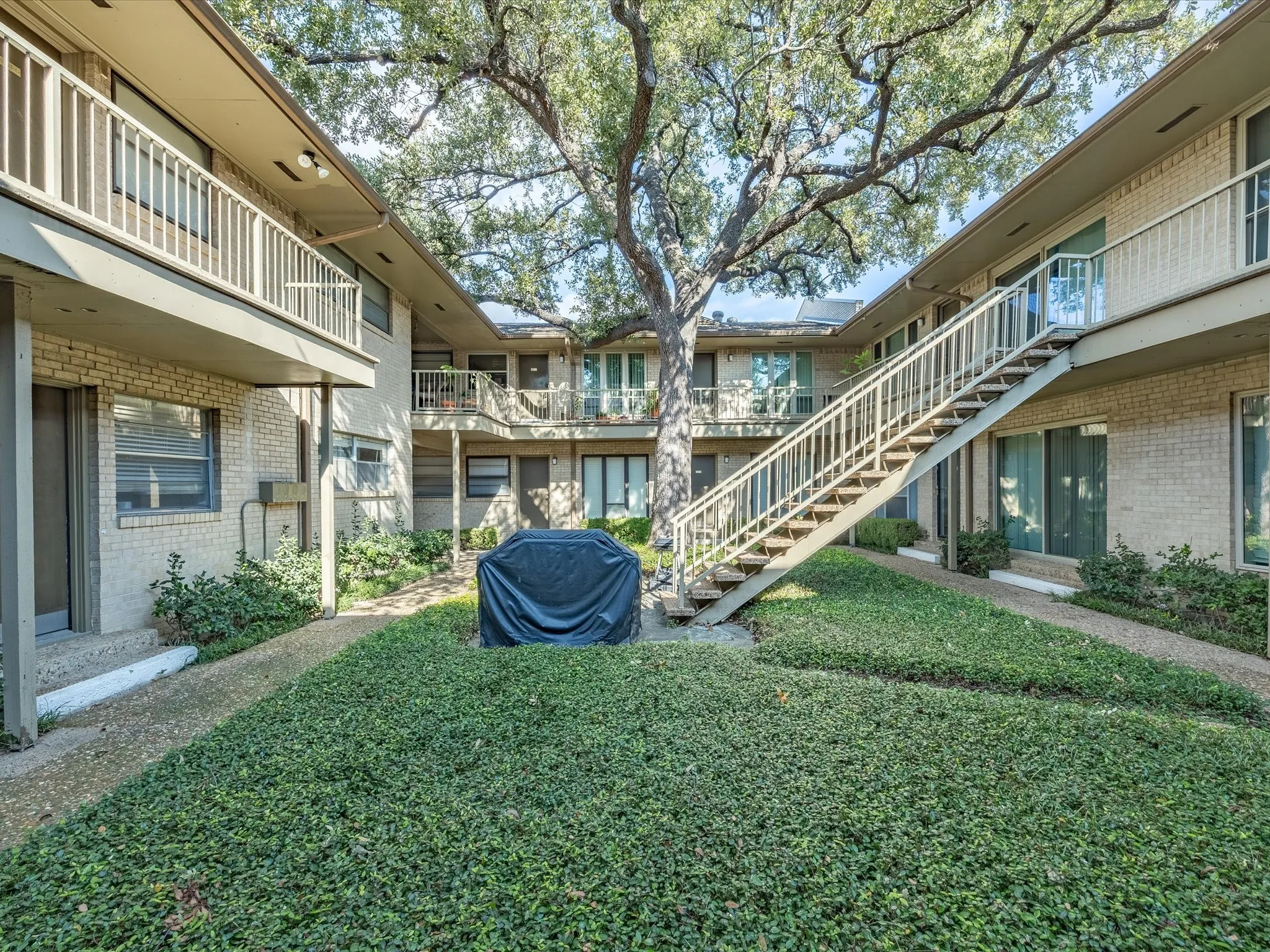 View of home's community featuring a balcony, a lawn, and stairway
