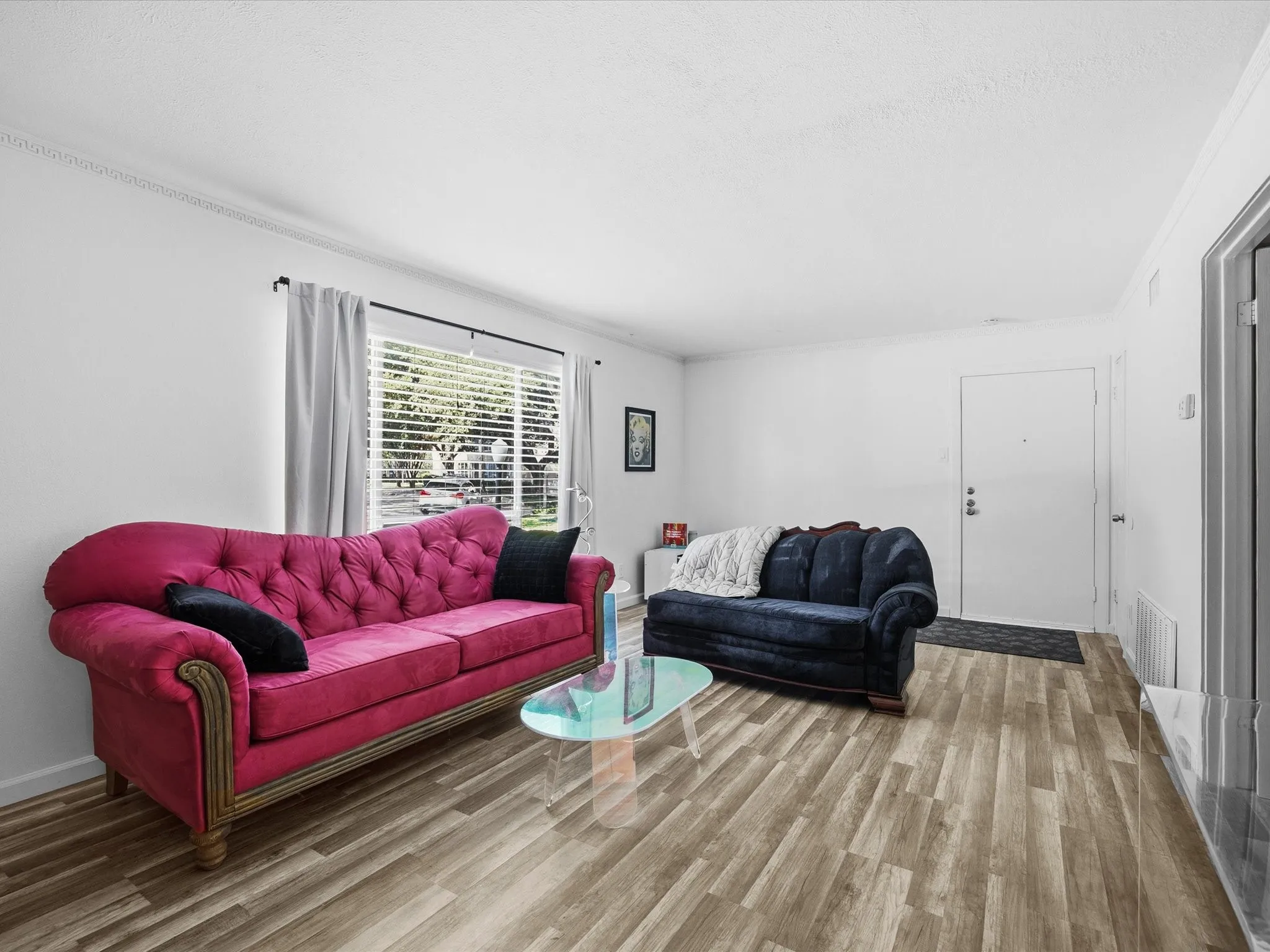 Living area with wood finished floors and ornamental molding