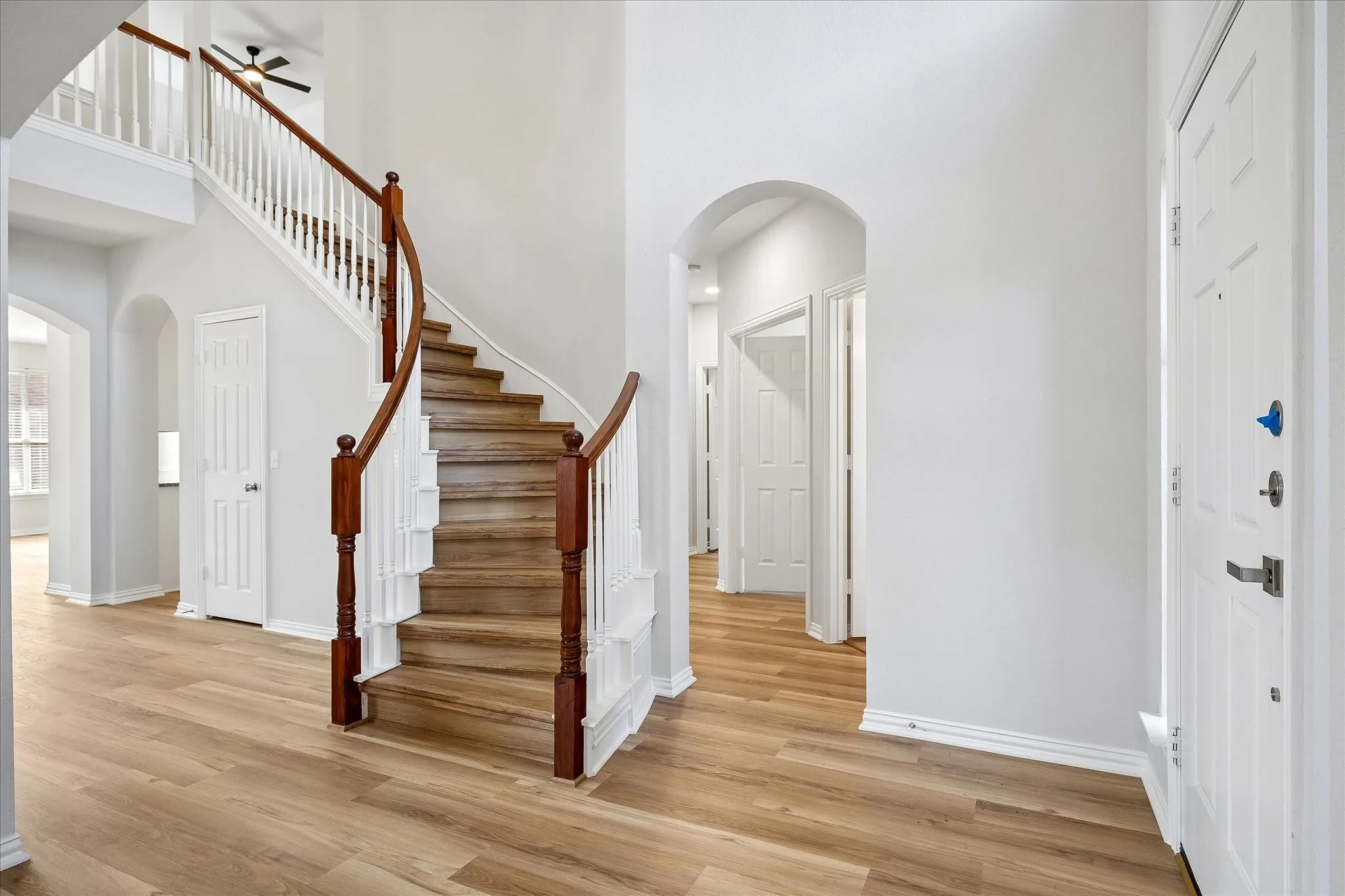 Grand entry featuring a curved staircase with wood-finish treads and white balusters