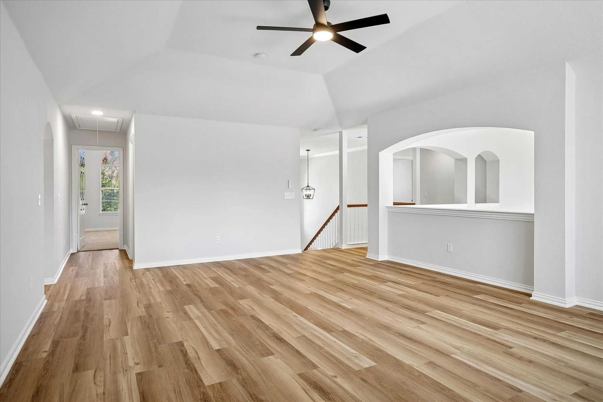 Game Room Spacious bonus room featuring vaulted ceilings, wood-finish flooring, and a large window with horizontal blinds