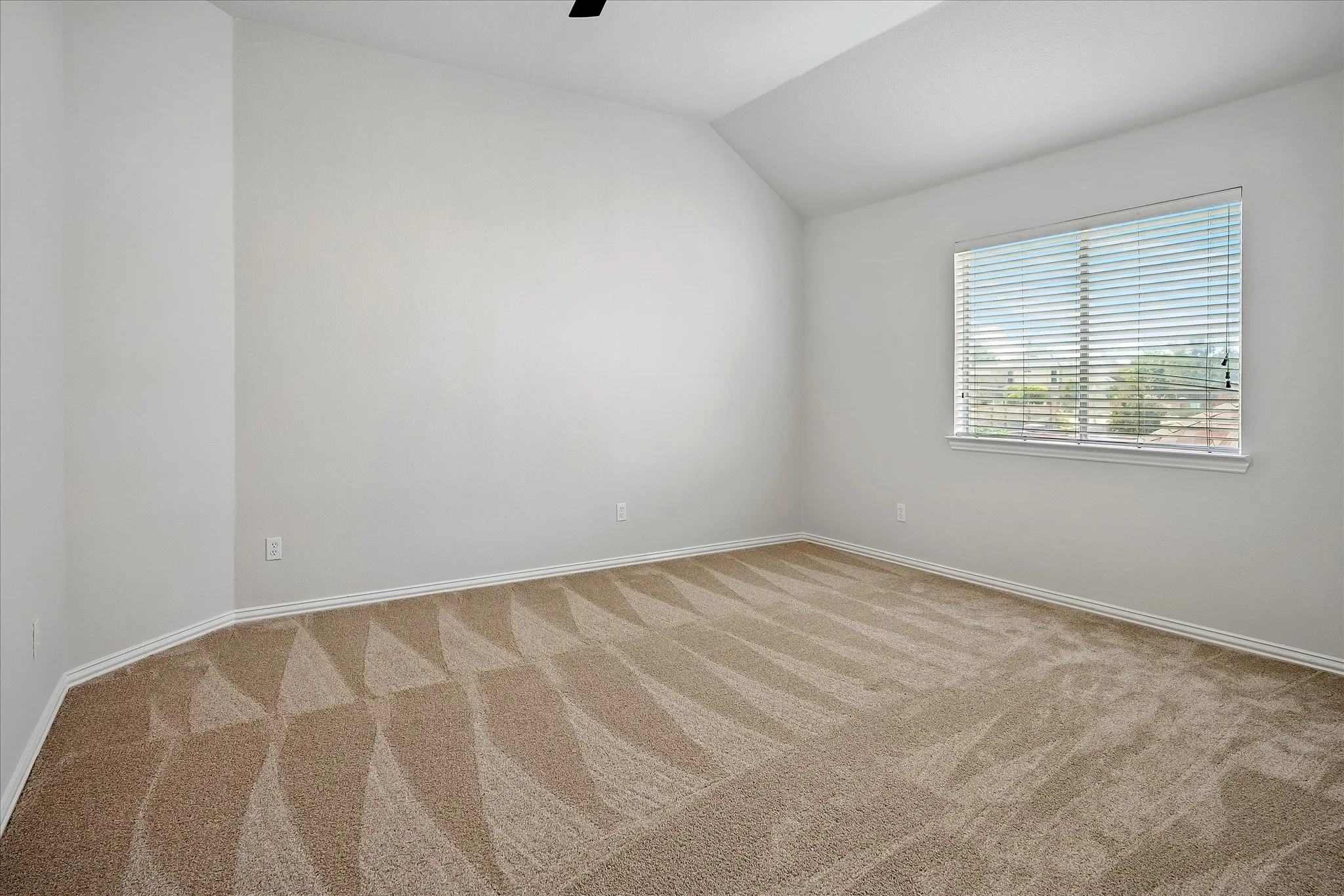 Spacious backyard featuring a manicured lawn, a mature tree, and a wood privacy fence