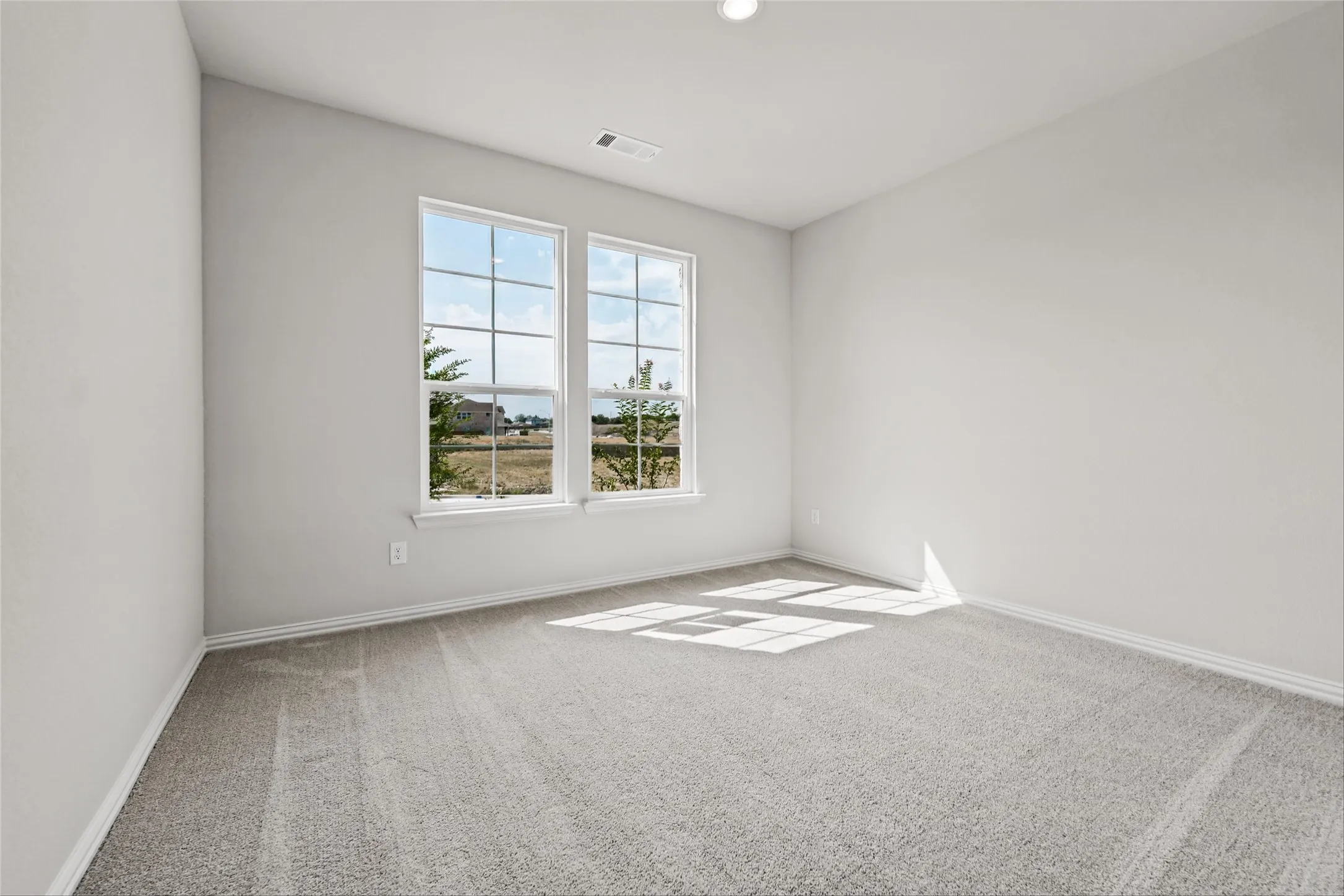 Neutral wall paint, dual windows, recessed ceiling lighting, and gray carpet flooring