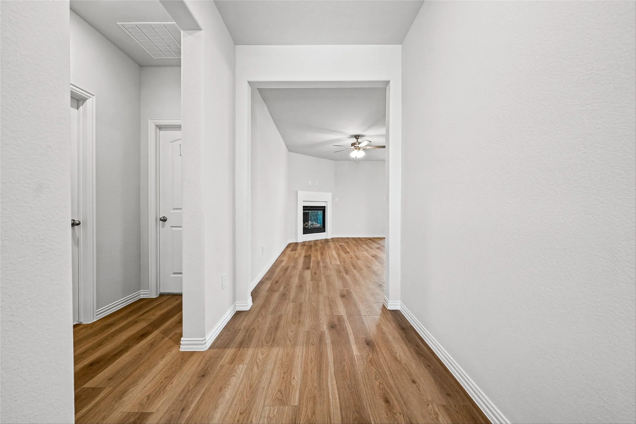 Wood-finish flooring throughout, white interior doors, and white baseboards