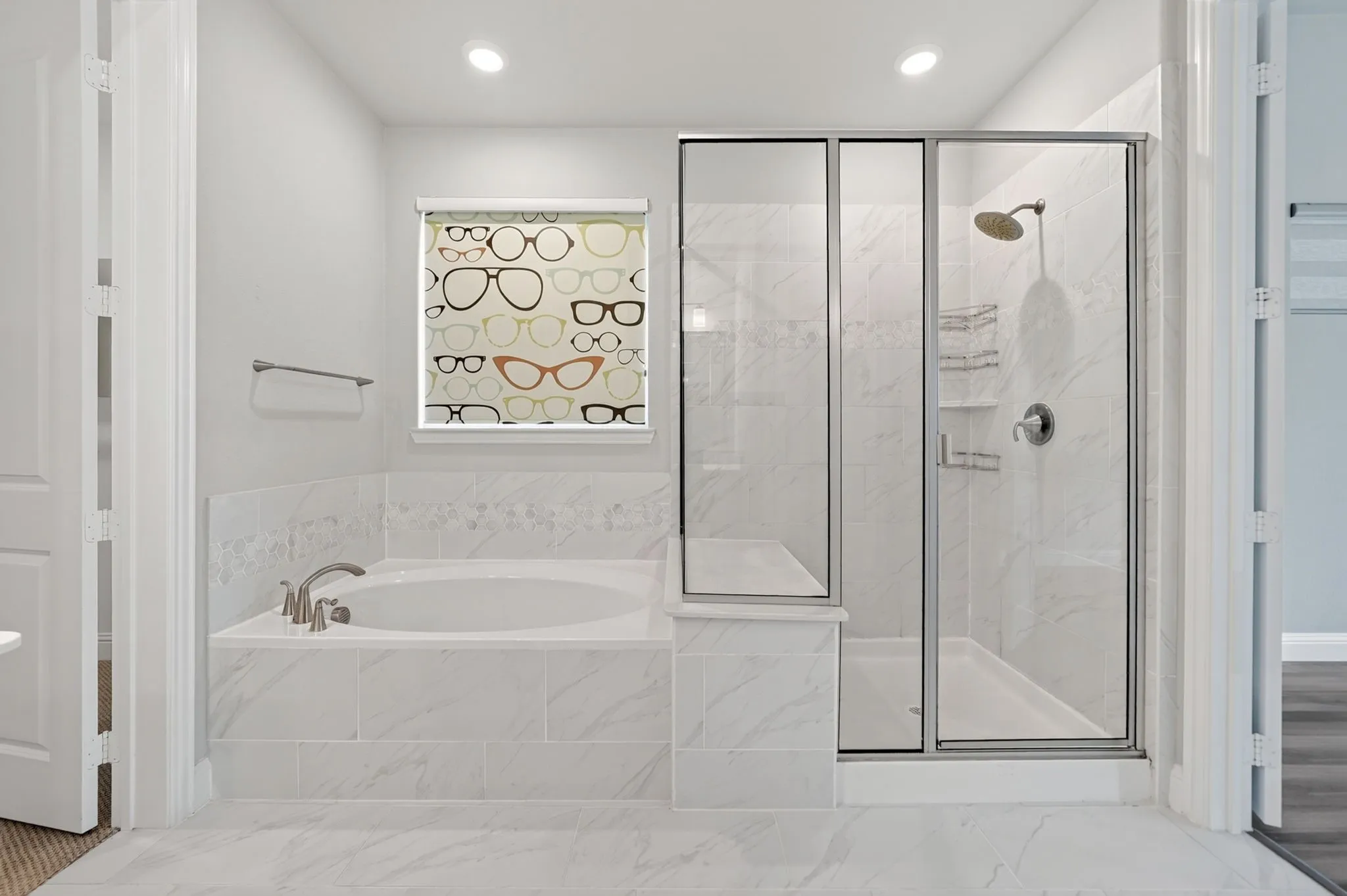 Bathroom featuring a built-in soaking tub with brushed nickel fixtures, a glass-enclosed shower with a rainfall showerhead, and white tiled flooring
