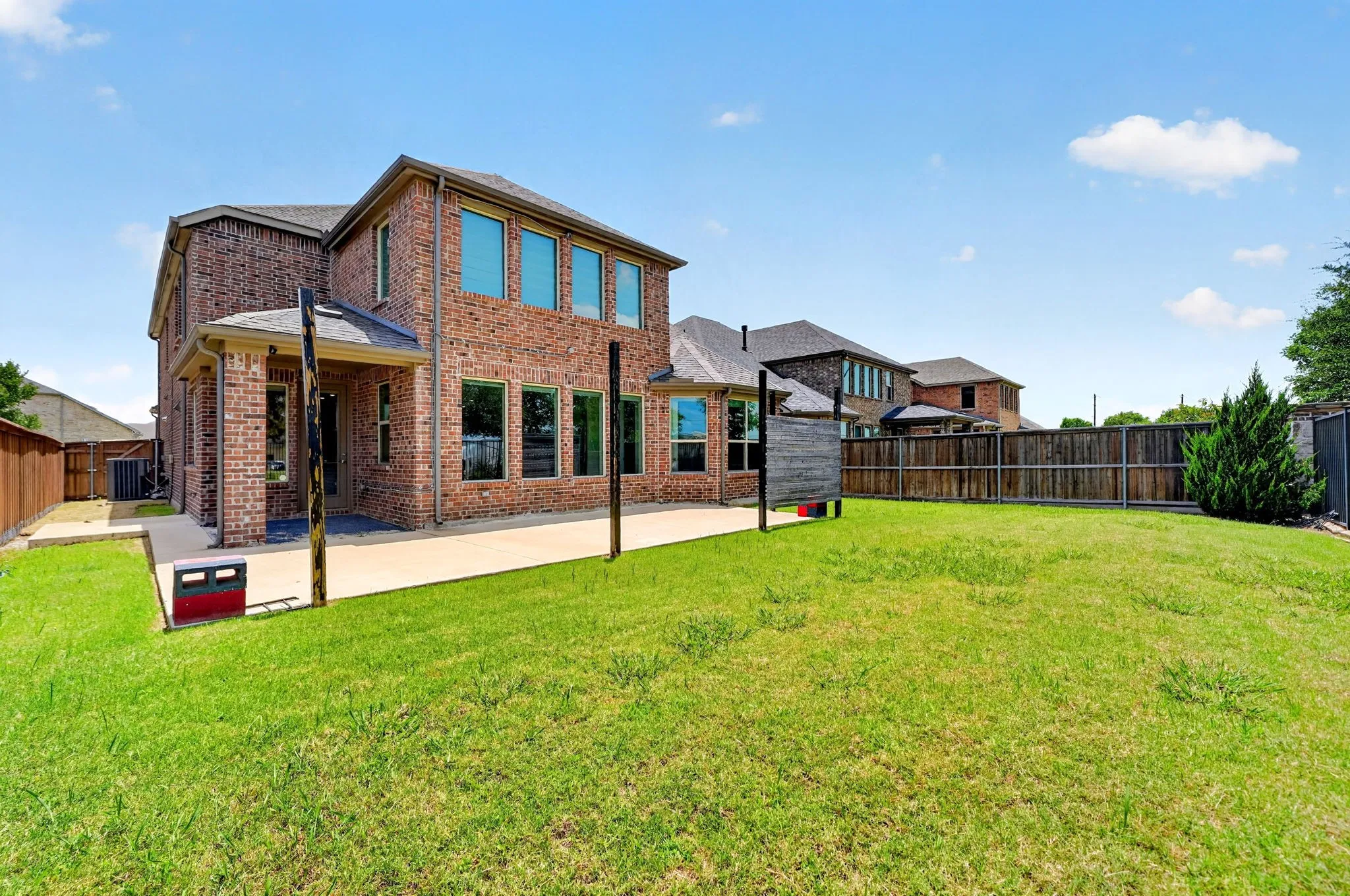 Expansive backyard featuring a lush lawn and a concrete patio