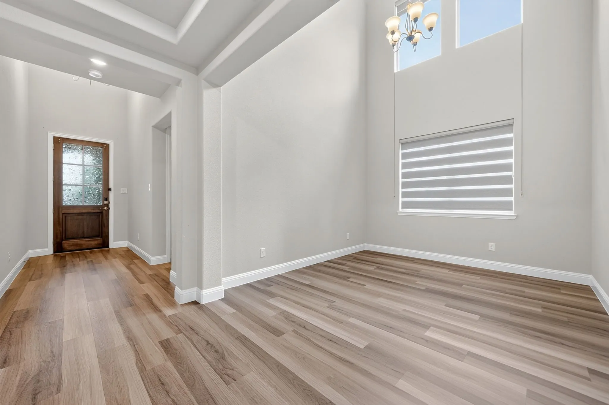 Entryway featuring a decorative wood-panel door with frosted glass, wood-finish flooring, recessed lighting, and a coffered ceiling