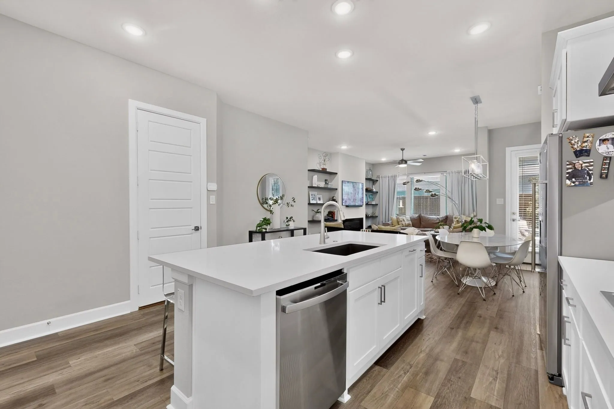 Kitchen island with white cabinetry, stainless steel dishwasher, and a rectangular sink