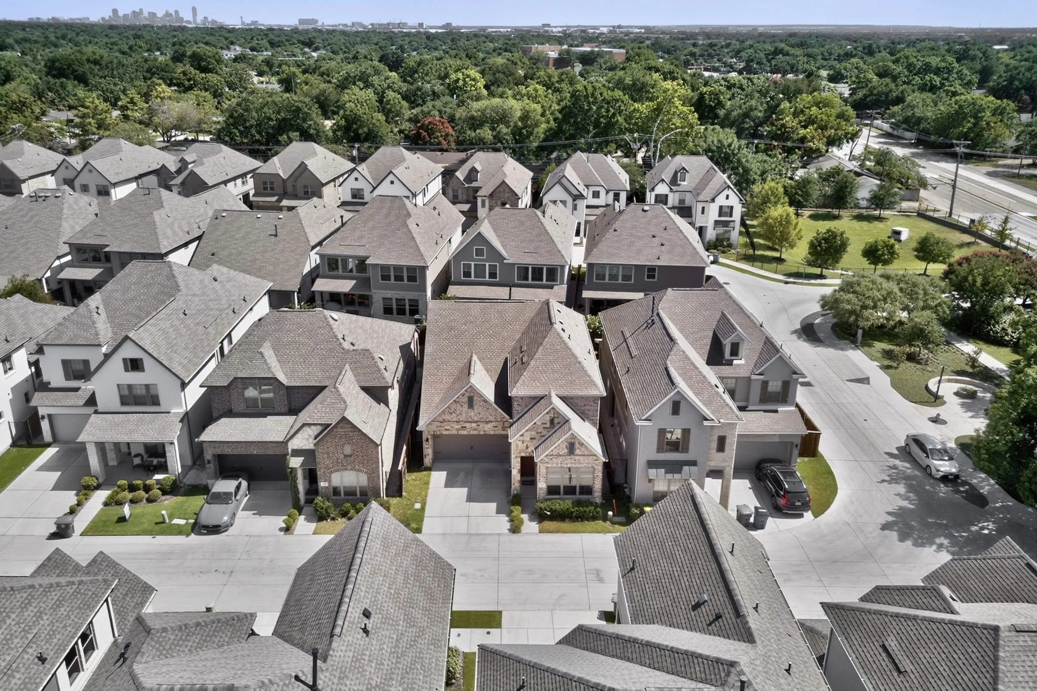 Residential neighborhood featuring a variety of architectural styles, tree-lined streets, and paved roadways