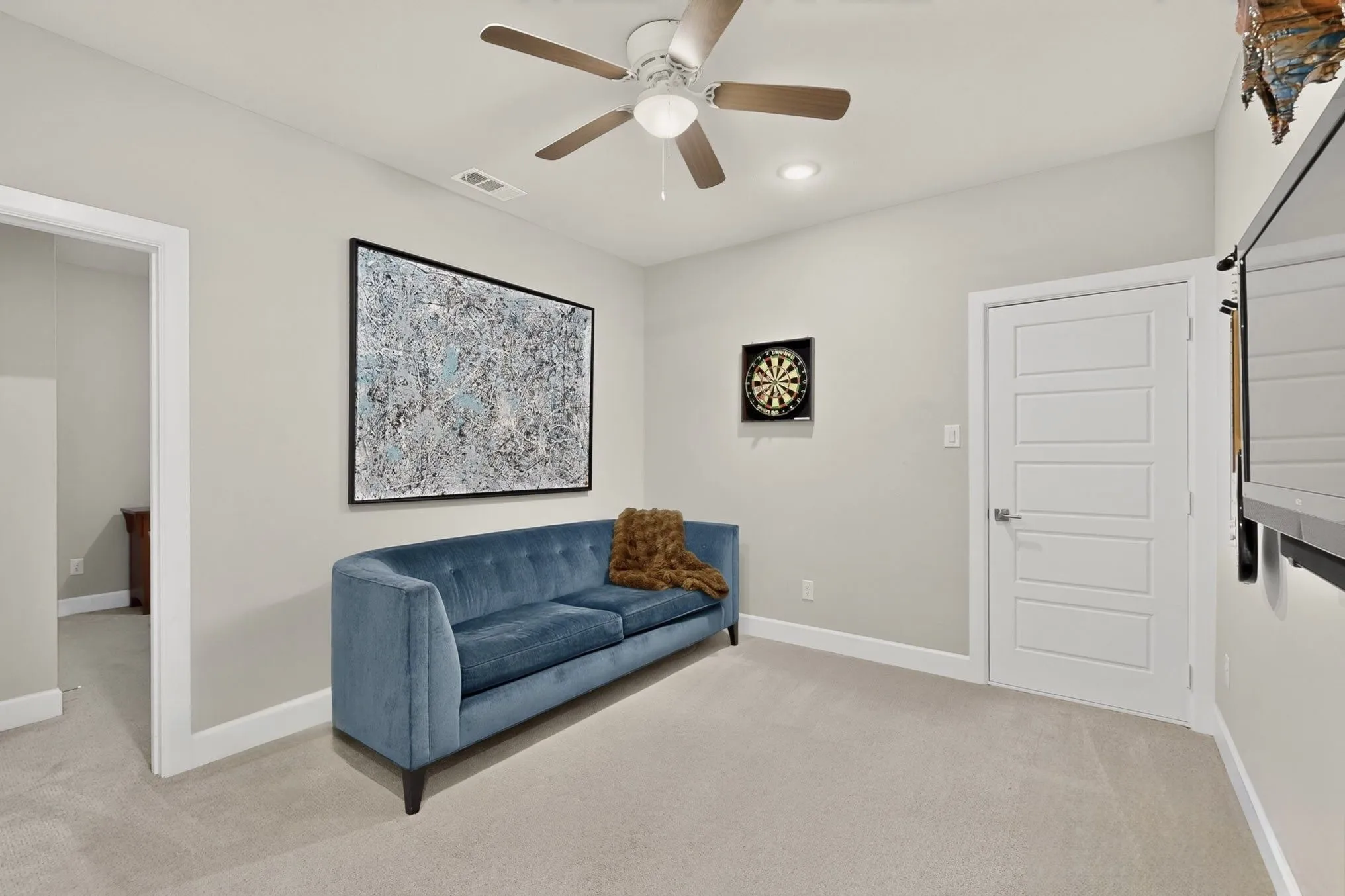 Carpeted room featuring a ceiling fan with integrated lighting, recessed ceiling light, and a five-panel interior door