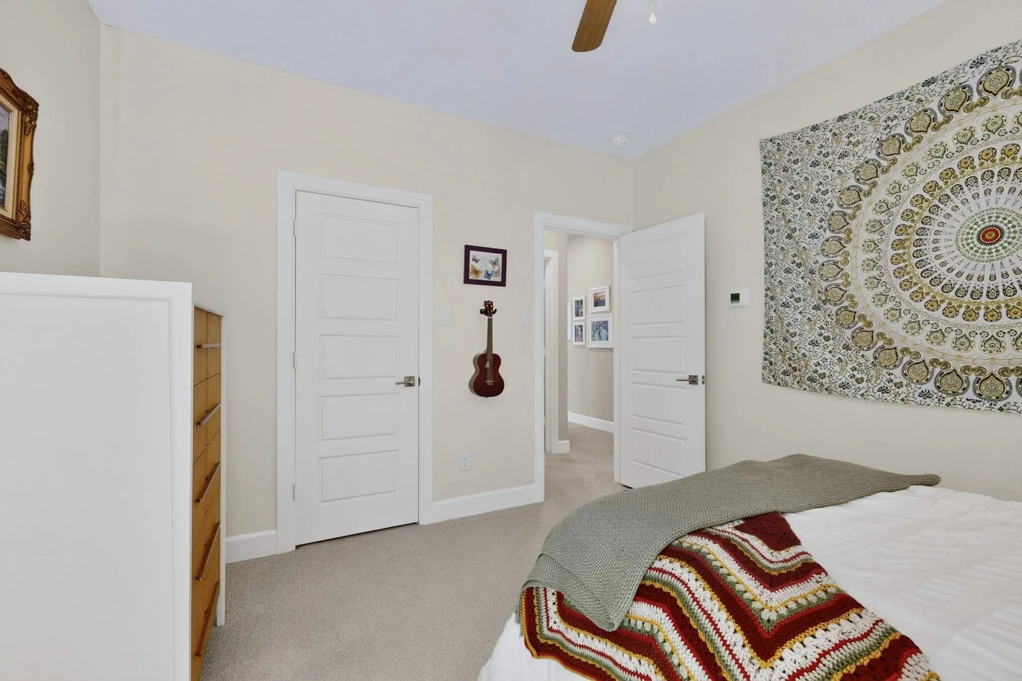Interior room featuring light neutral wall paint, carpet flooring, a ceiling fan, and white five-panel interior doors