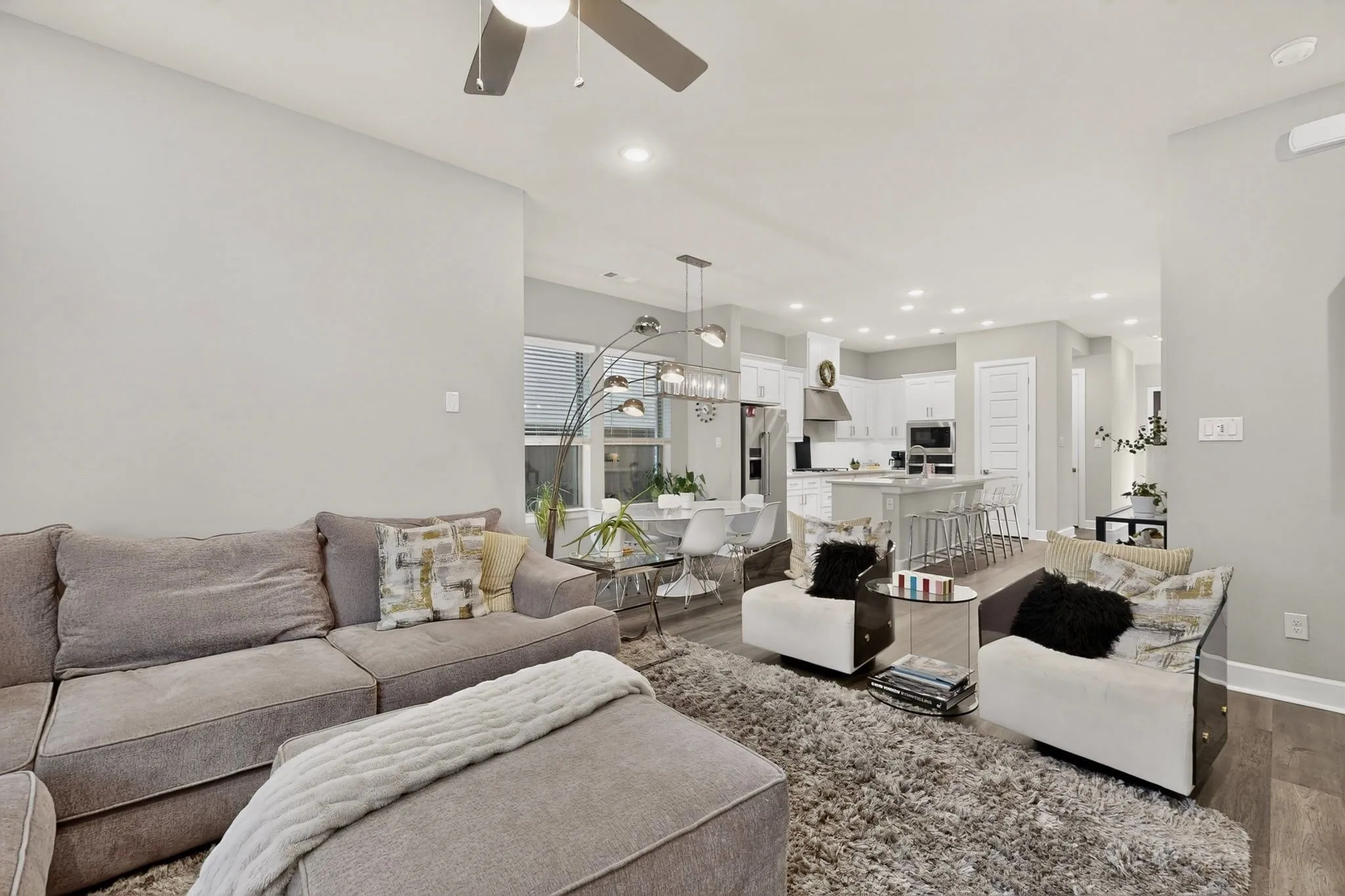 Open-concept living space featuring wood-finish flooring, recessed lighting, and a ceiling fan