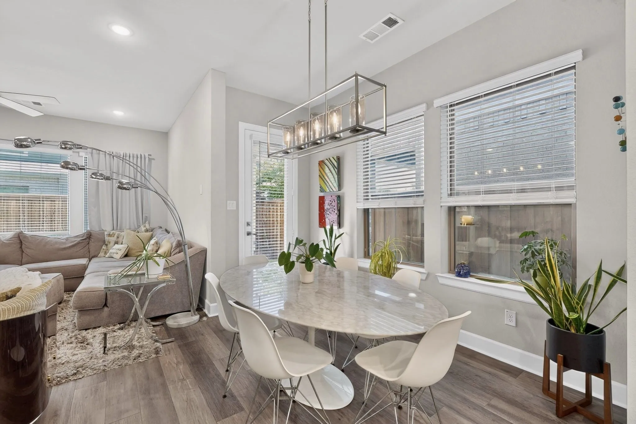 Open-concept dining area with wood-finish flooring, recessed lighting, and a contemporary linear chandelier