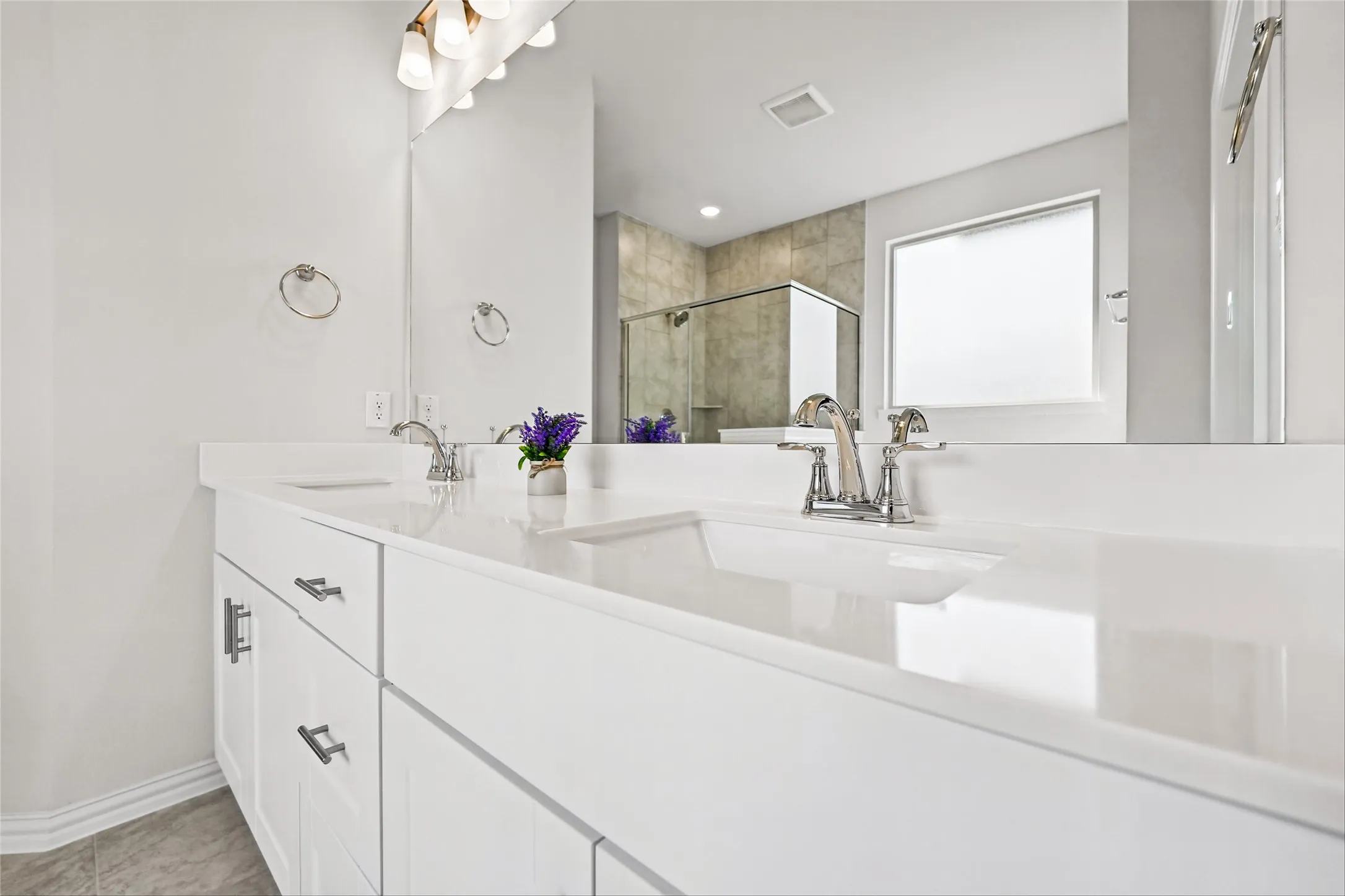 Dual vanity with white cabinetry, polished chrome faucets, and integrated rectangular sinks