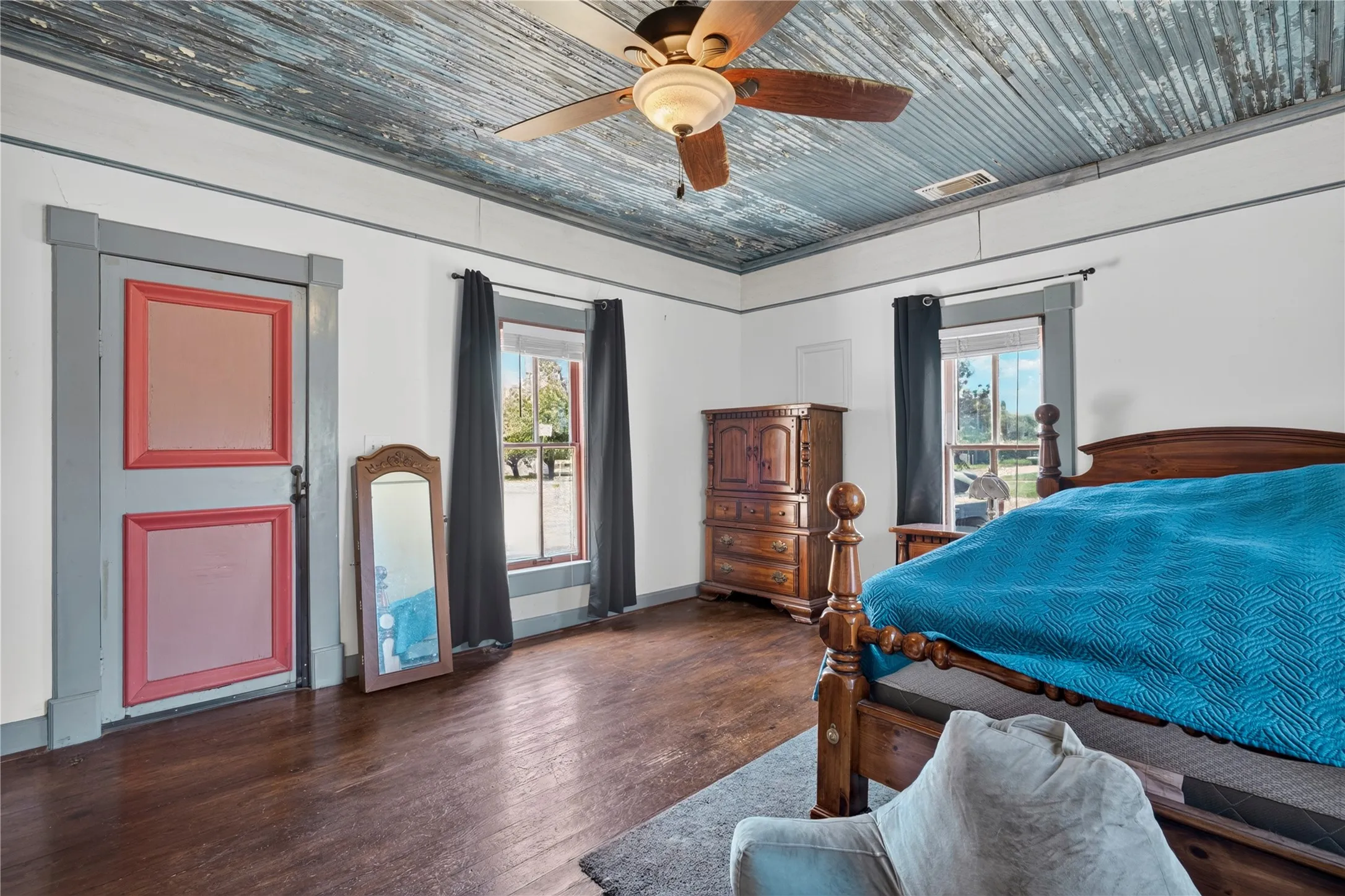 Spacious room featuring a wood ceiling, wood-finish flooring, a ceiling fan with integrated lighting, and multiple windows