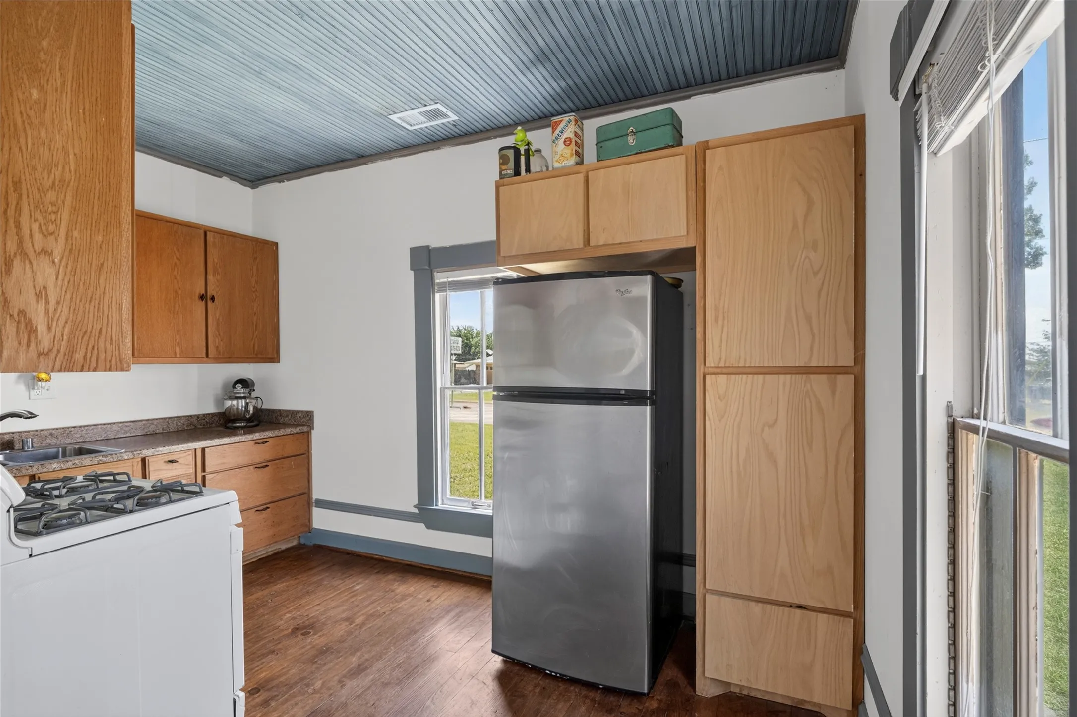 Kitchen featuring wood-finish cabinetry, wood-finish flooring, and a beadboard ceiling