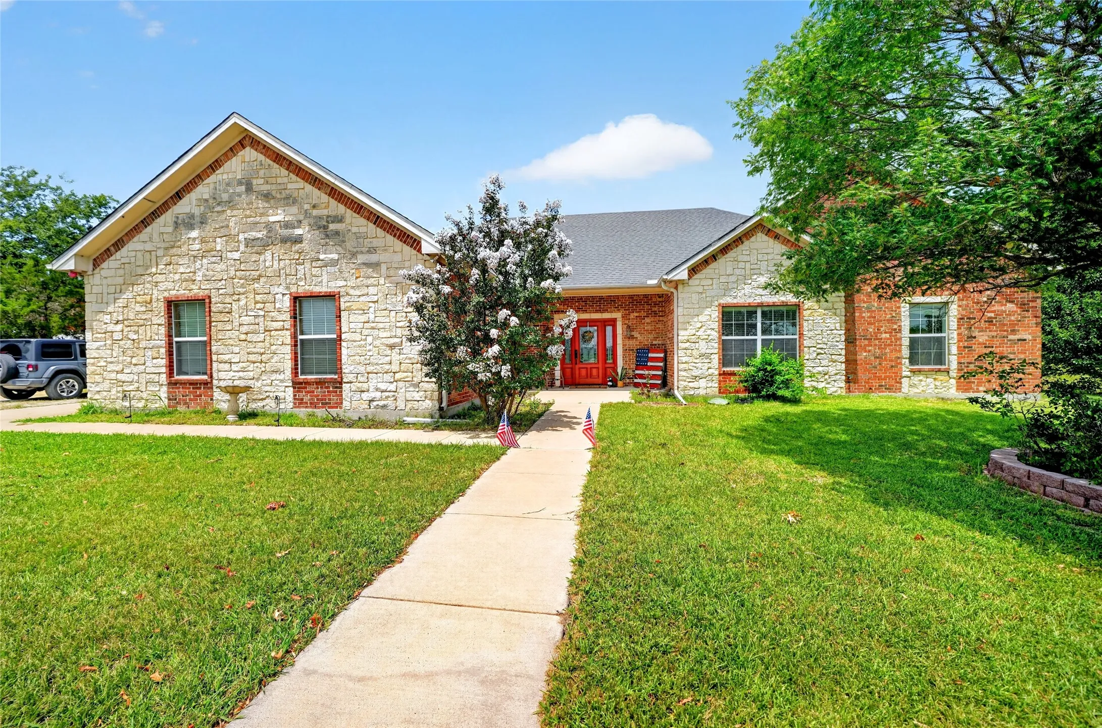 Stone and brick exterior with a red front door