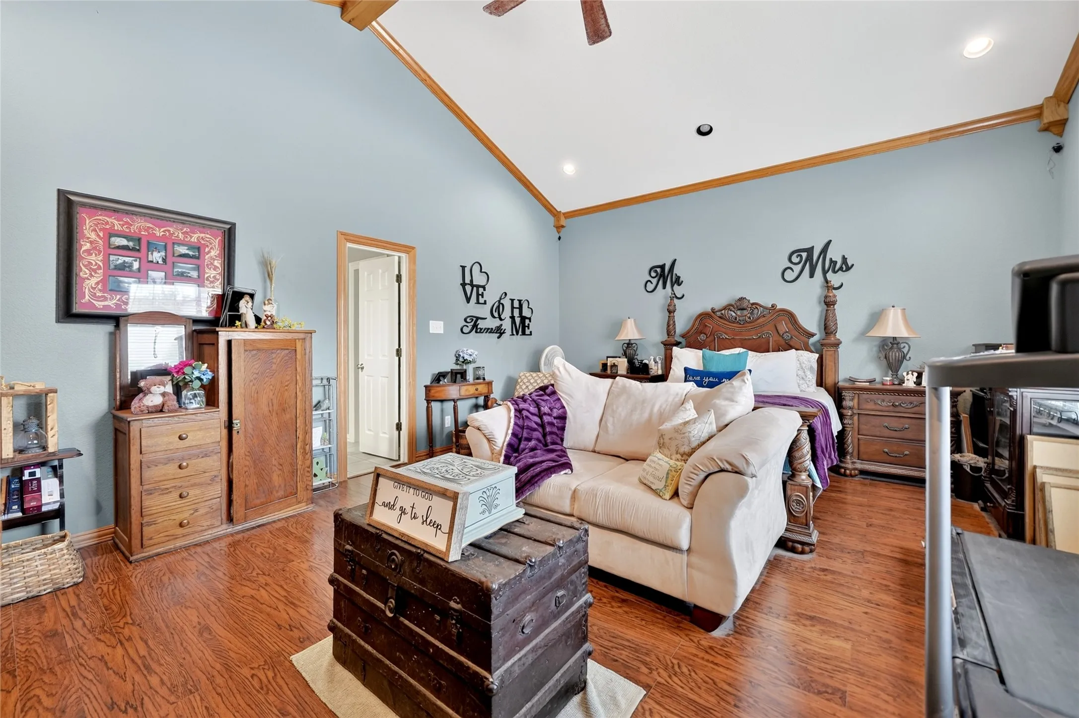 Vaulted ceiling with exposed wood beams, ceiling fan, recessed lighting, wood-finish flooring, and light blue wall color